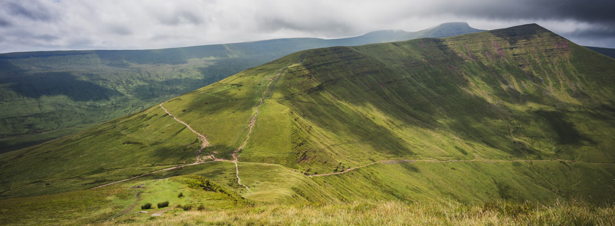 Green mountain slopes and hiking trails in the Brecon Beacons, Wales