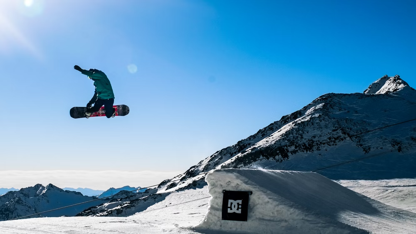 Snowboarder performing a jump at Stubai Glacier in the Alps