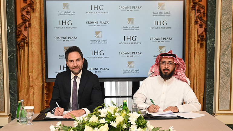 Two men sign hotel agreement at Crowne Plaza event