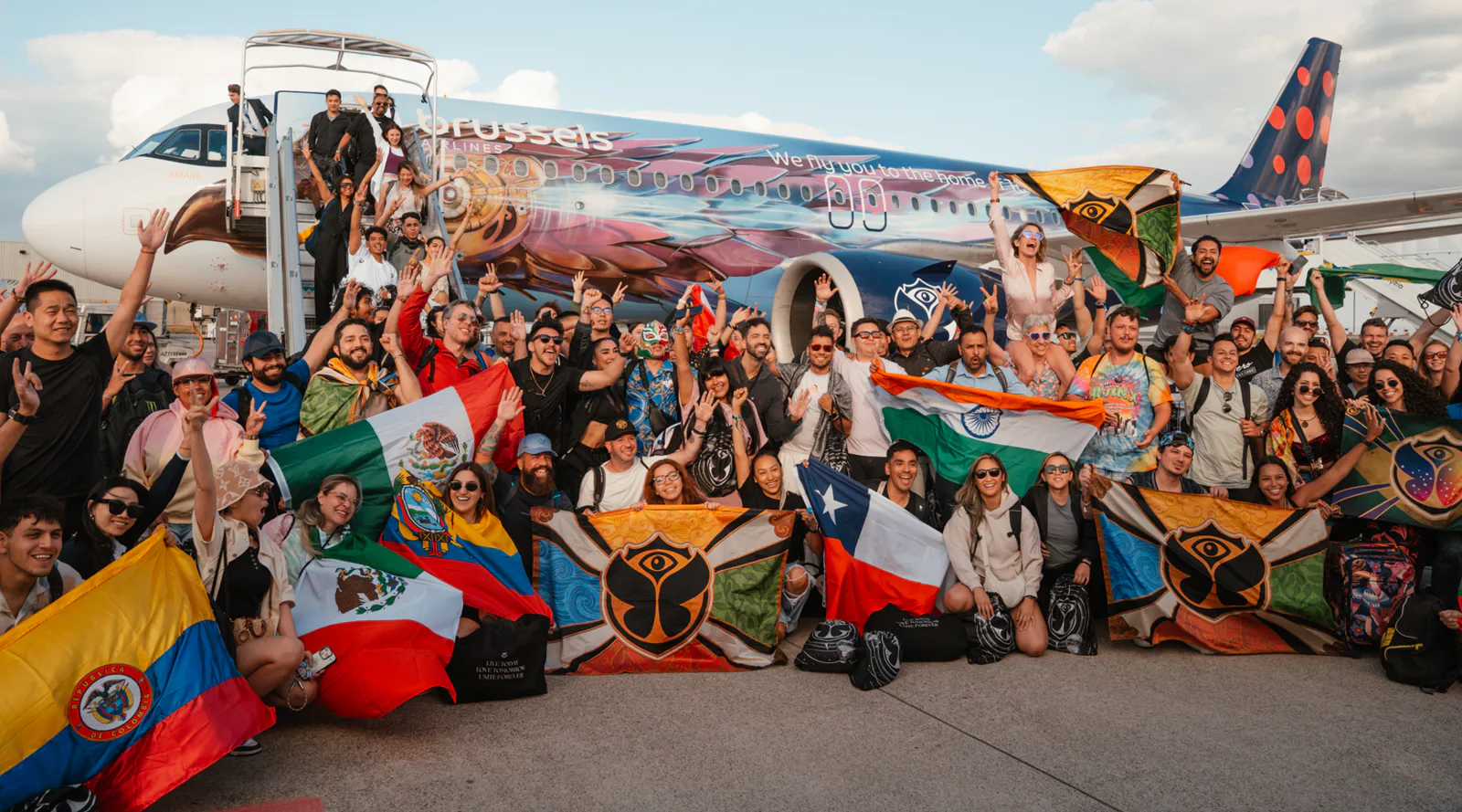 Festivalgoers with national flags arrive at Tomorrowland flight in Belgium