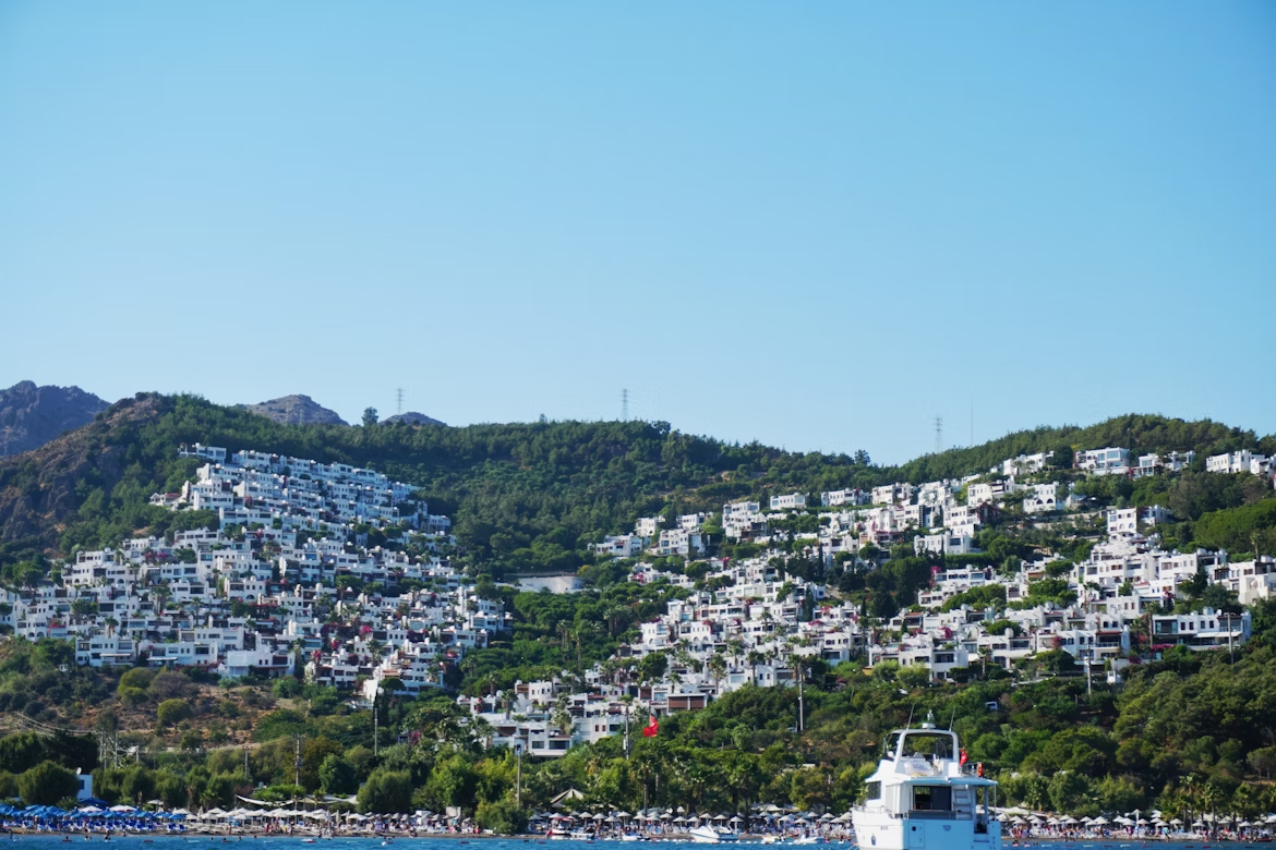 View of white hillside houses and beach in Turgutreis, Türkiye