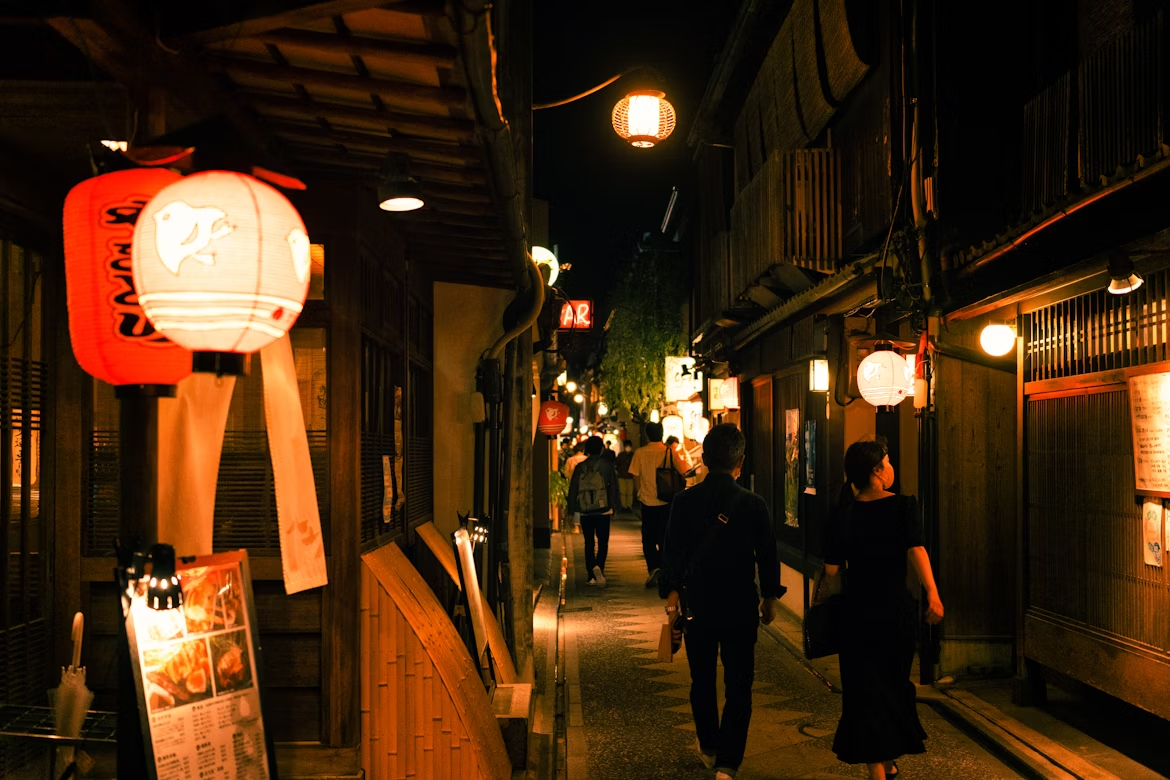 Evening view of Pontocho Alley with lanterns and pedestrians in Kyoto