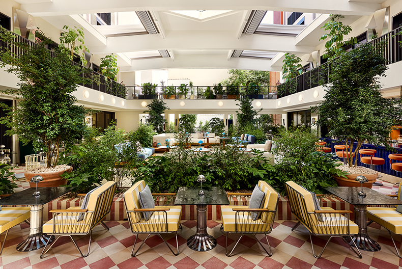 Lush indoor courtyard at W Florence hotel with greenery and modern seating