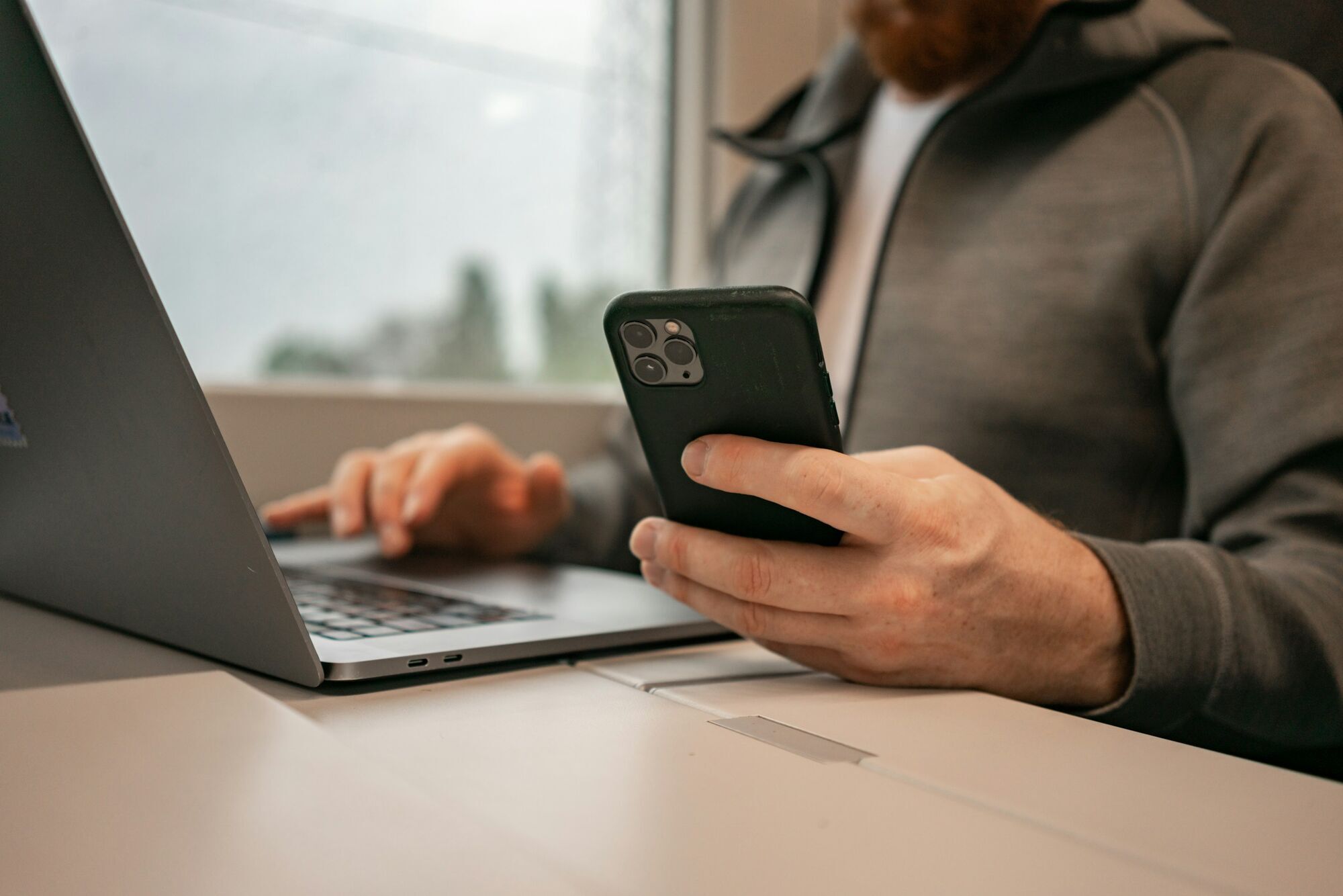 Traveler using smartphone and laptop to manage plans