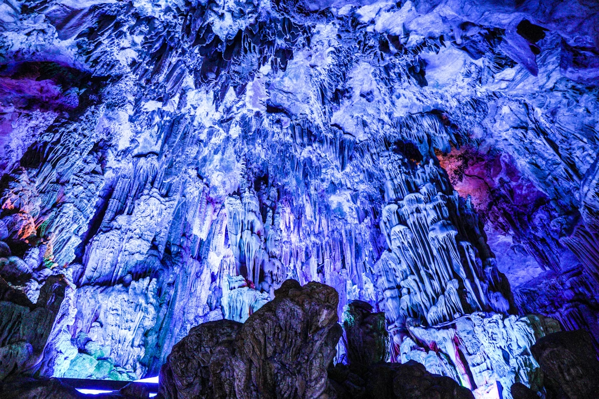 Illuminated stalactites and formations inside Prometheus Cave in Georgia