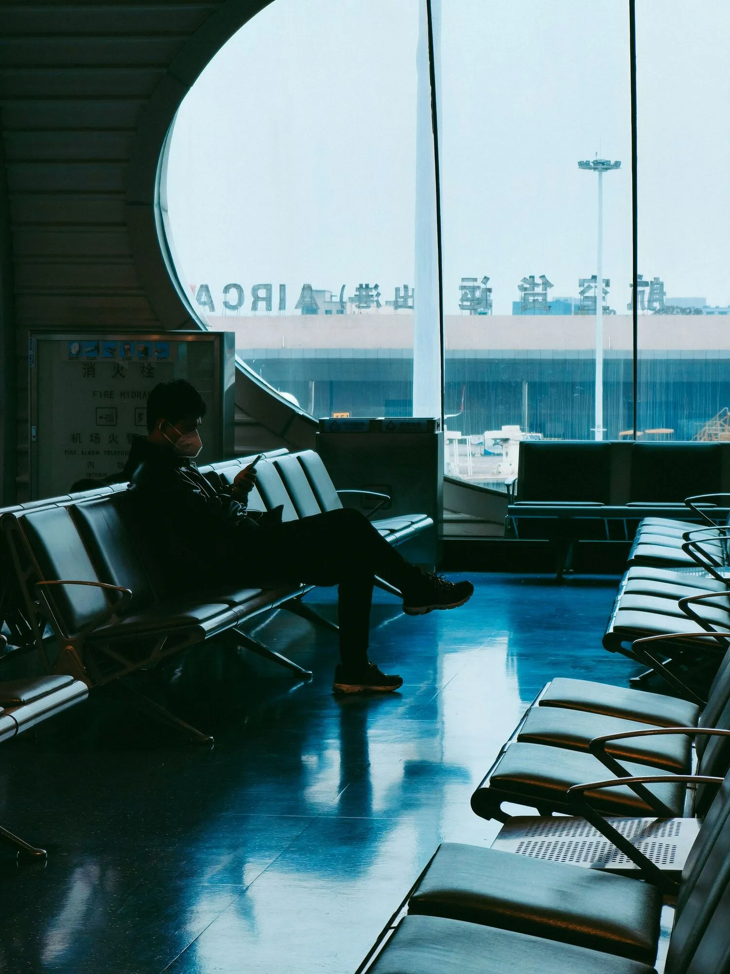 Traveler using phone while waiting at airport terminal