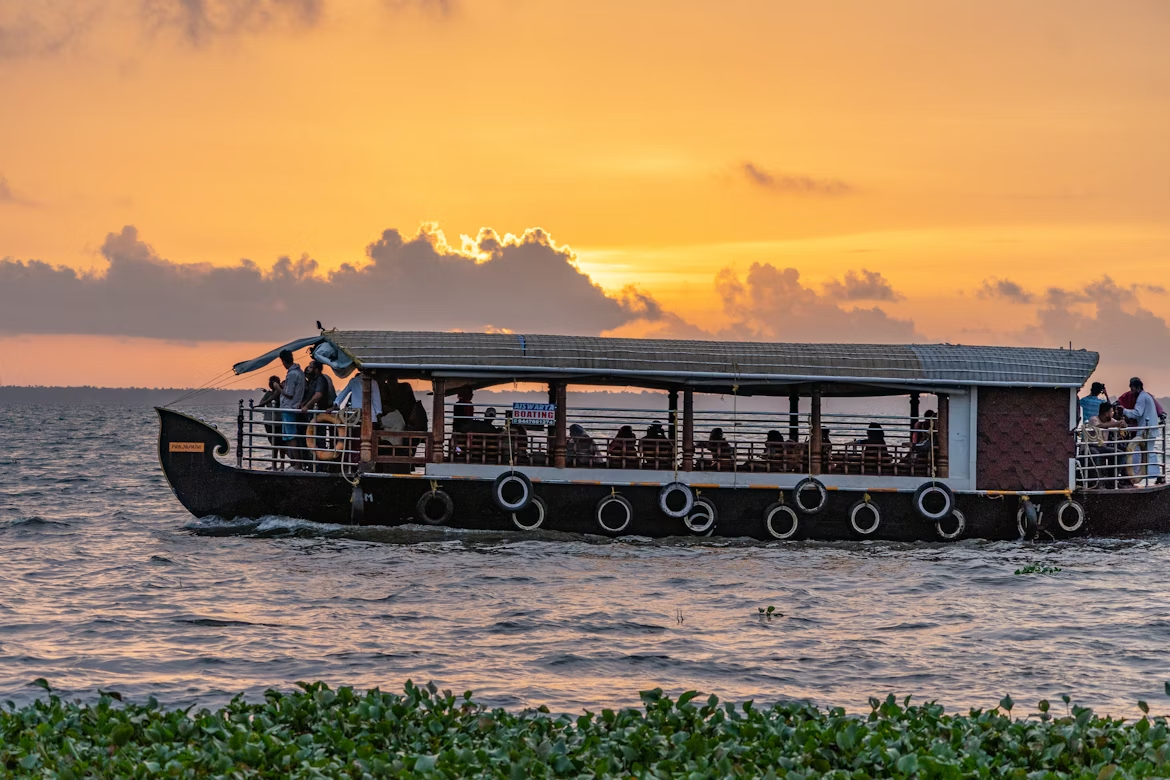Passenger boat cruising at sunset with people on board