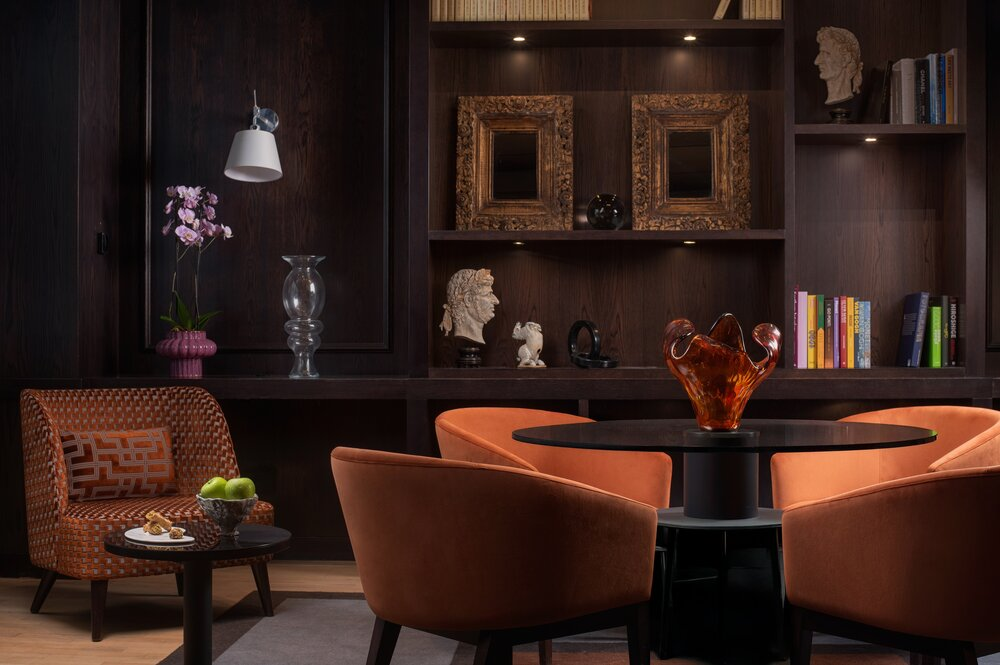 Modern lounge area with orange chairs and decorative shelving