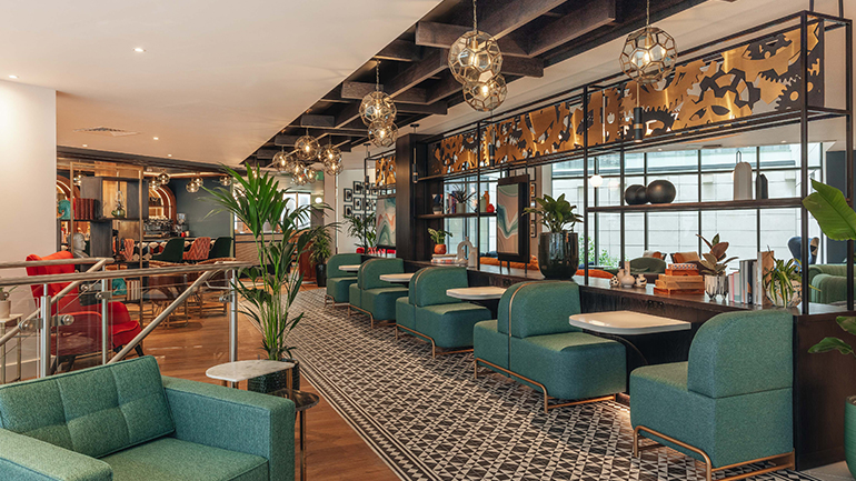 Modern lounge area with green seating and decorative lighting