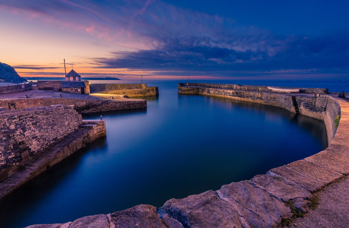 Charlestown Harbour at sunset with calm water and historic stone walls