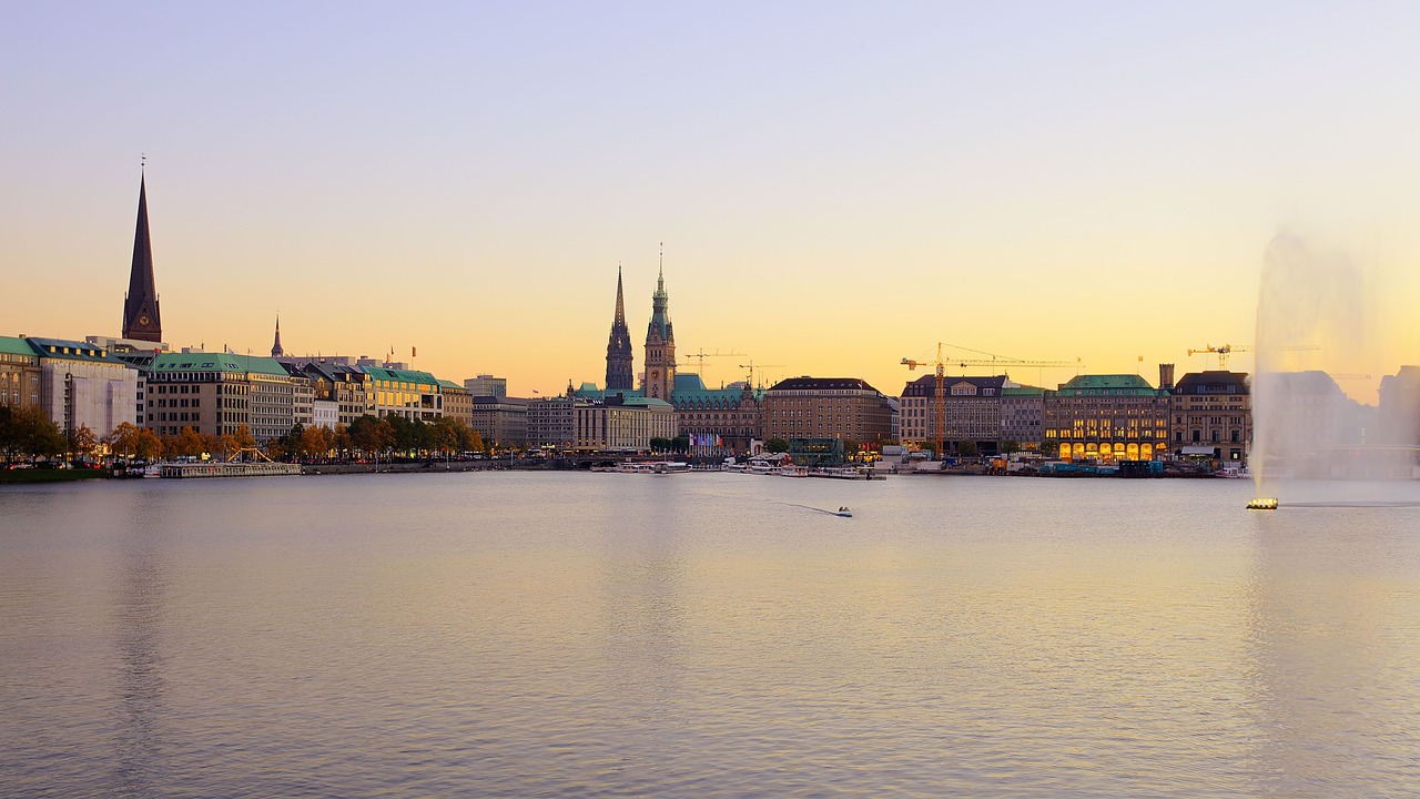 View of Hamburg's Alster Lakes at sunset with city skyline and water fountain