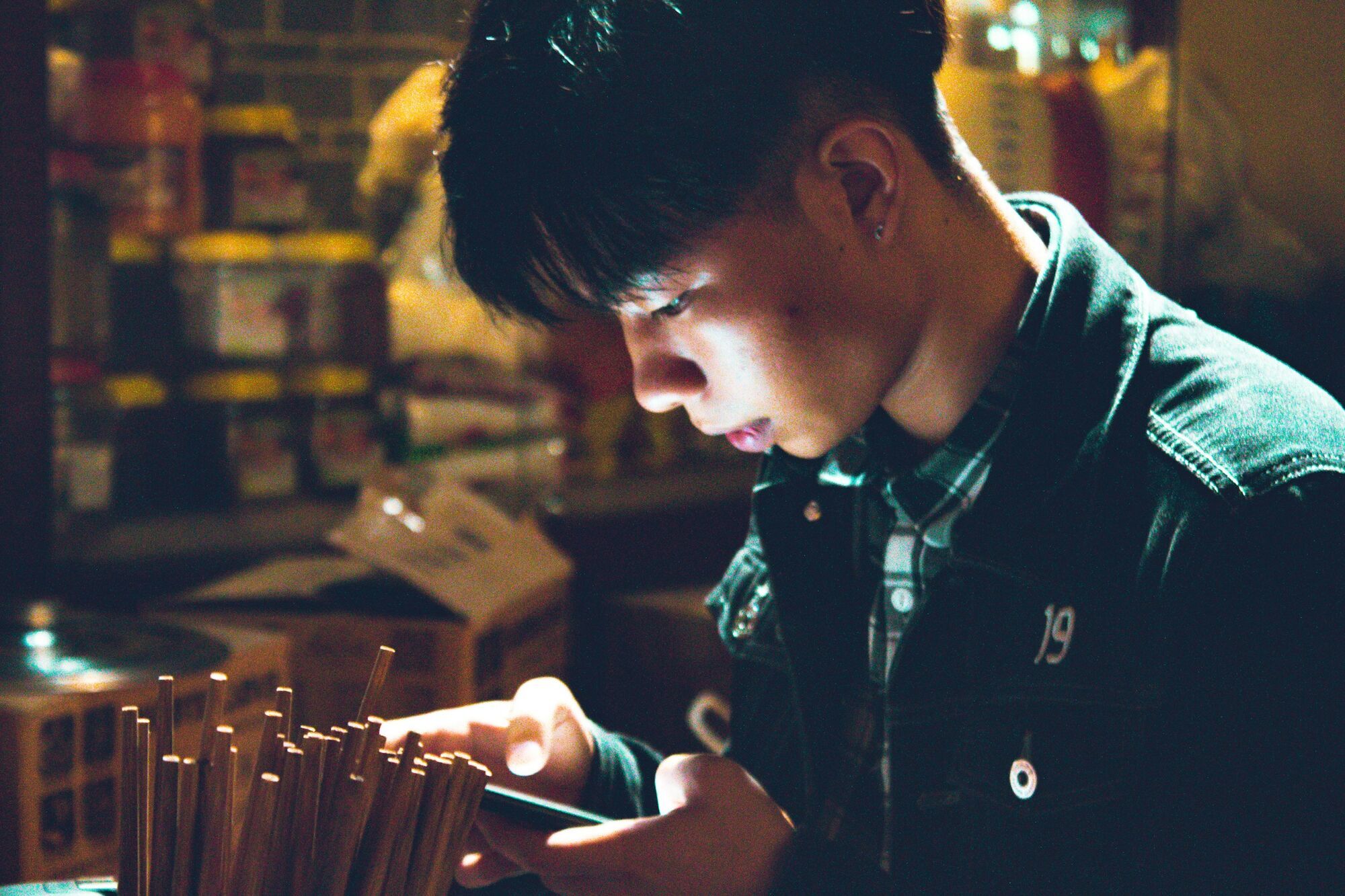 Young man using smartphone in low light