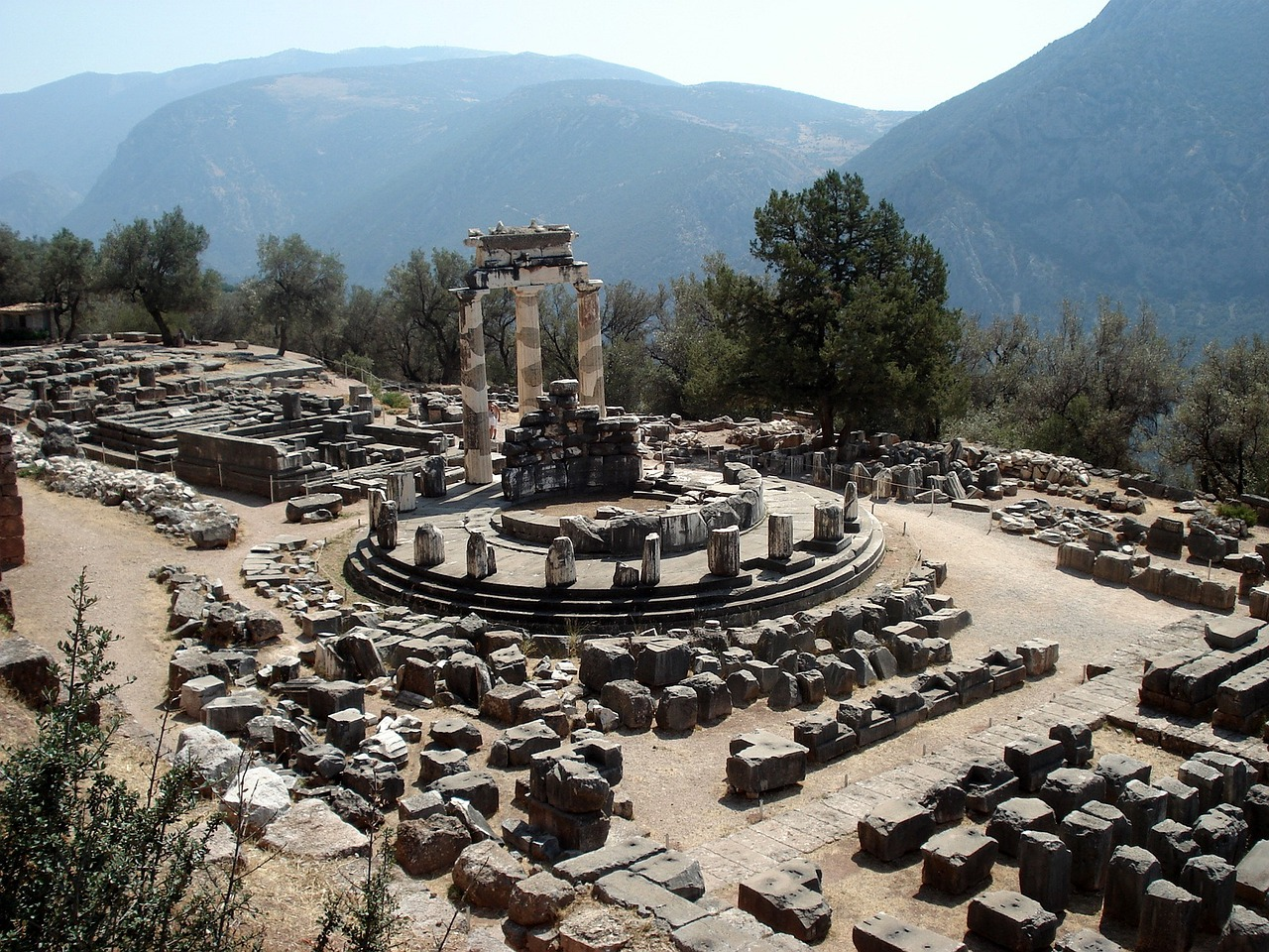 Ruins of the Oracle’s temple at Delphi surrounded by stone foundations and mountains
