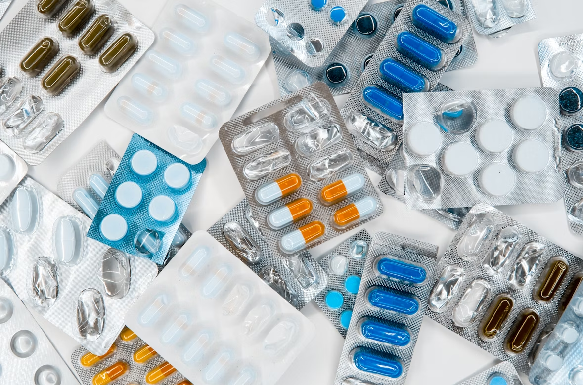 Assorted blister packs of various medicines on a white surface