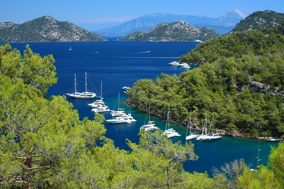 Yachts anchored in a forested bay along the Turkish coast