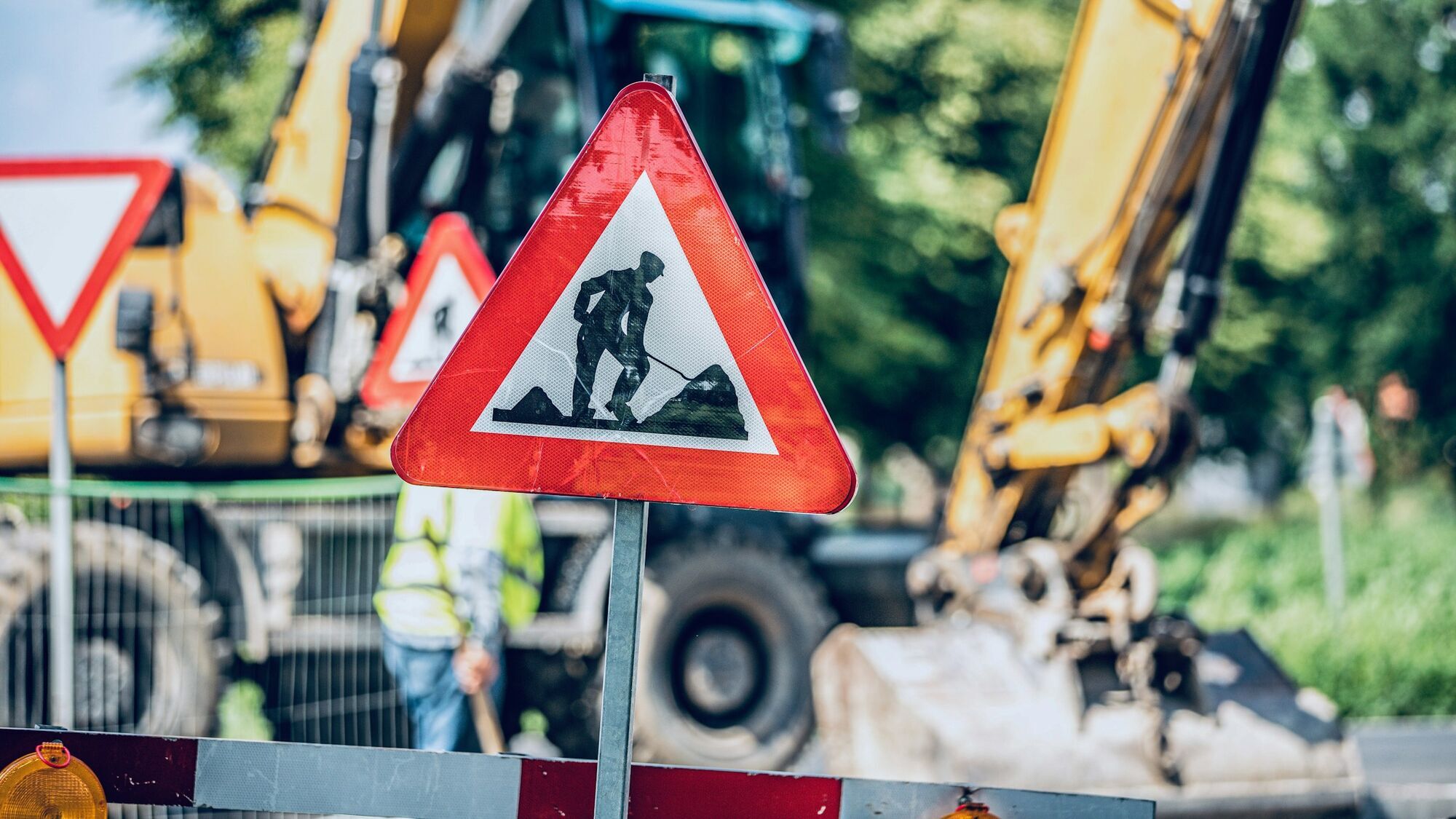 Roadworks sign with construction site in the background