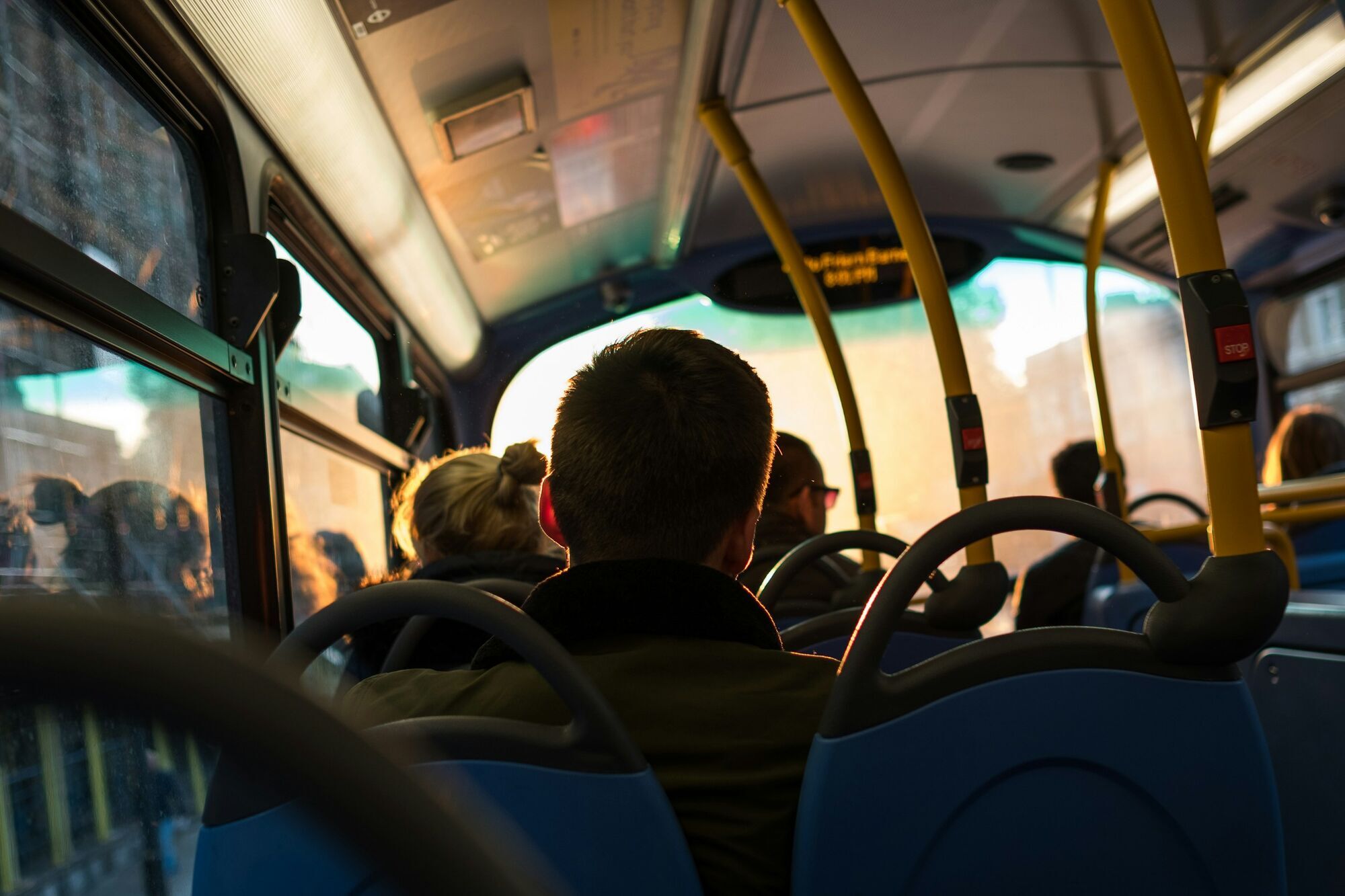Passengers sitting inside a bus during sunset ride