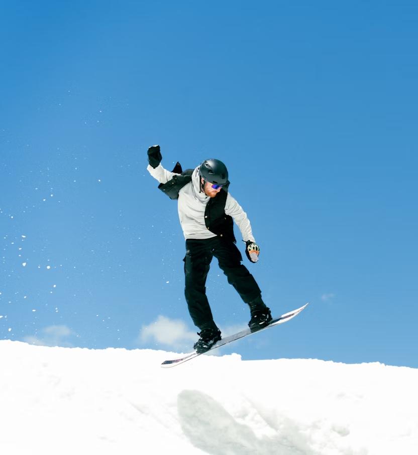 Snowboarder performing a jump against clear blue sky