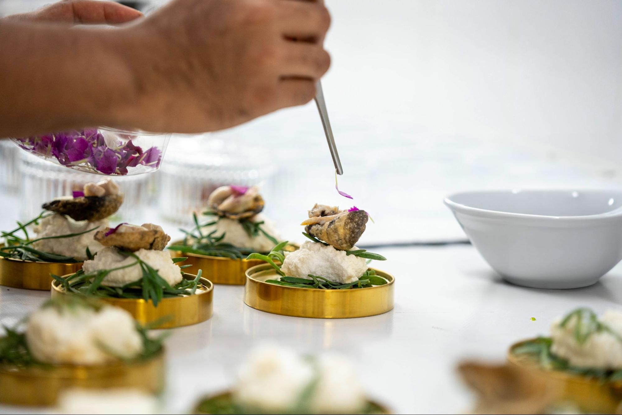 Chef garnishing gourmet dishes with edible flowers