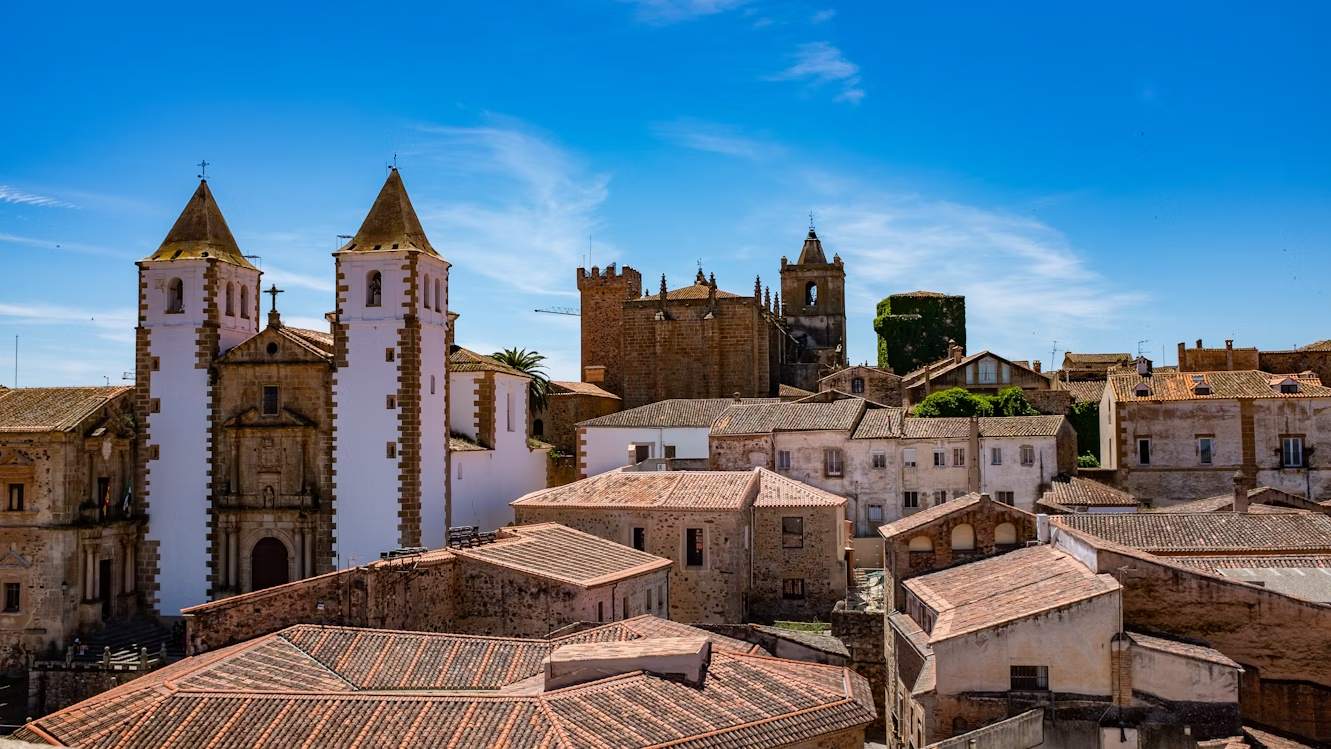 Historic buildings and rooftops in Cáceres old town under a clear blue sky