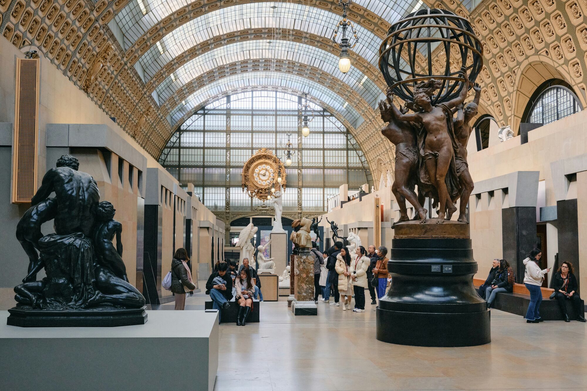 Interior of the Musée d’Orsay with visitors observing sculptures under the large station clock