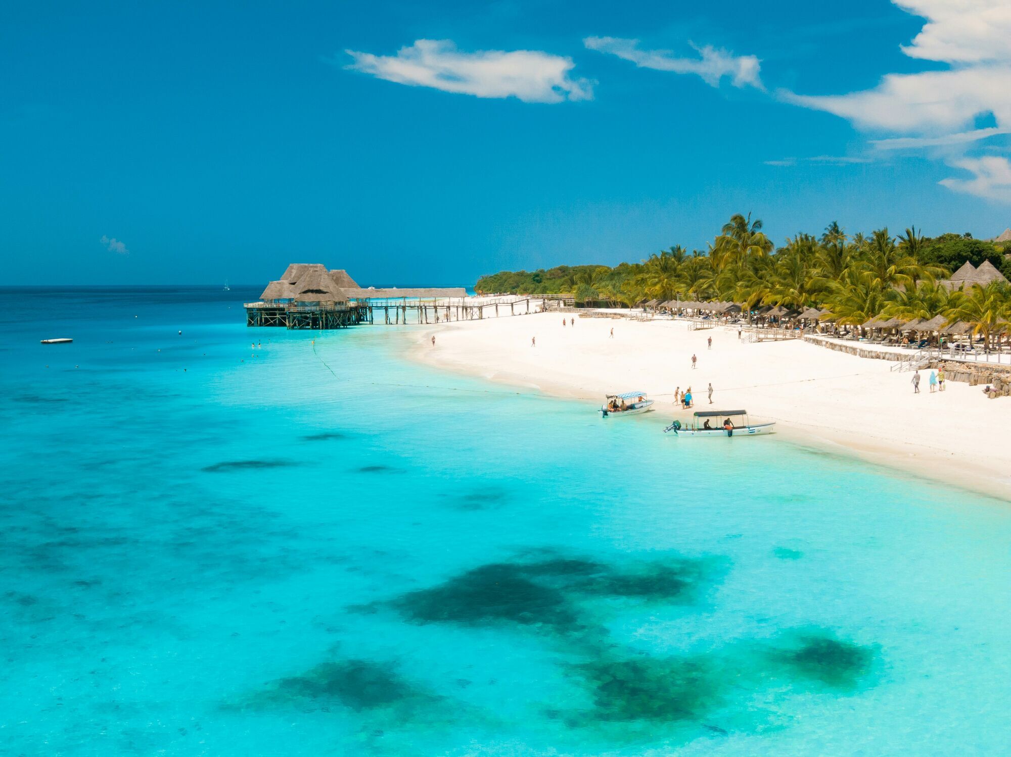 White-sand beach and turquoise sea with palm trees in Zanzibar
