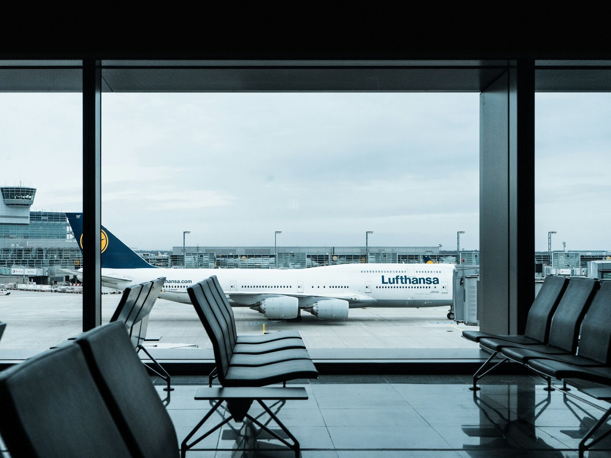 Aircraft at airport gate viewed through terminal window