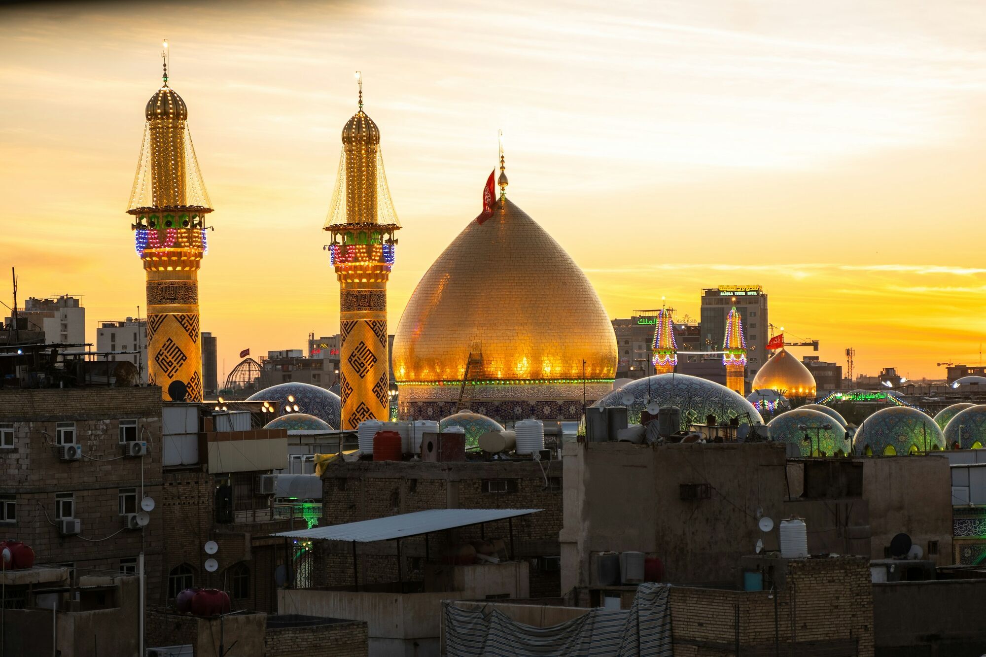 City skyline in Iraq at sunset with illuminated mosque