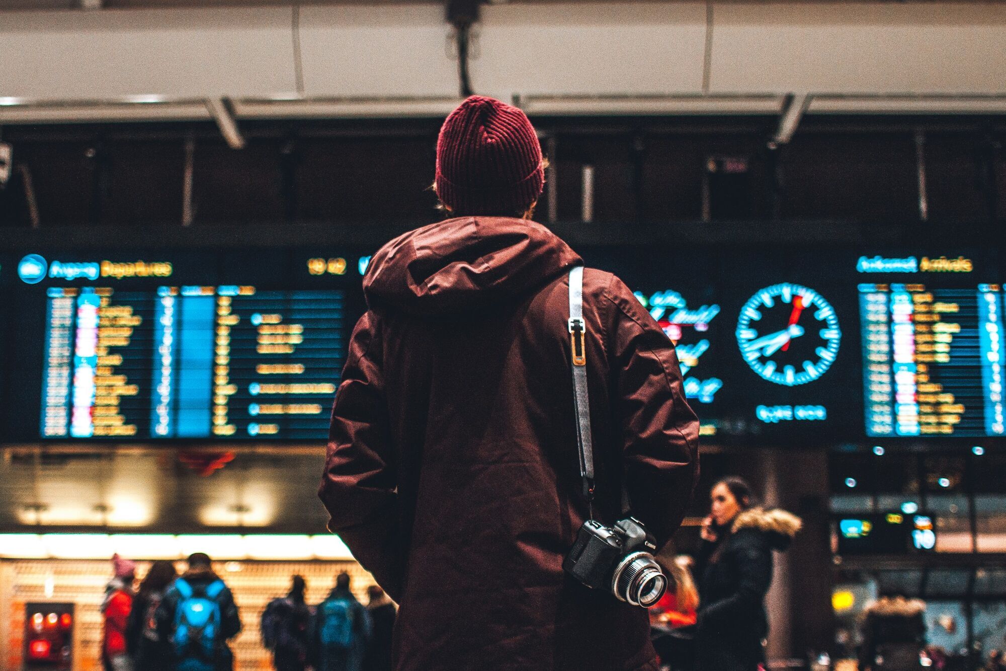 Traveller checking departure board at a busy transport hub
