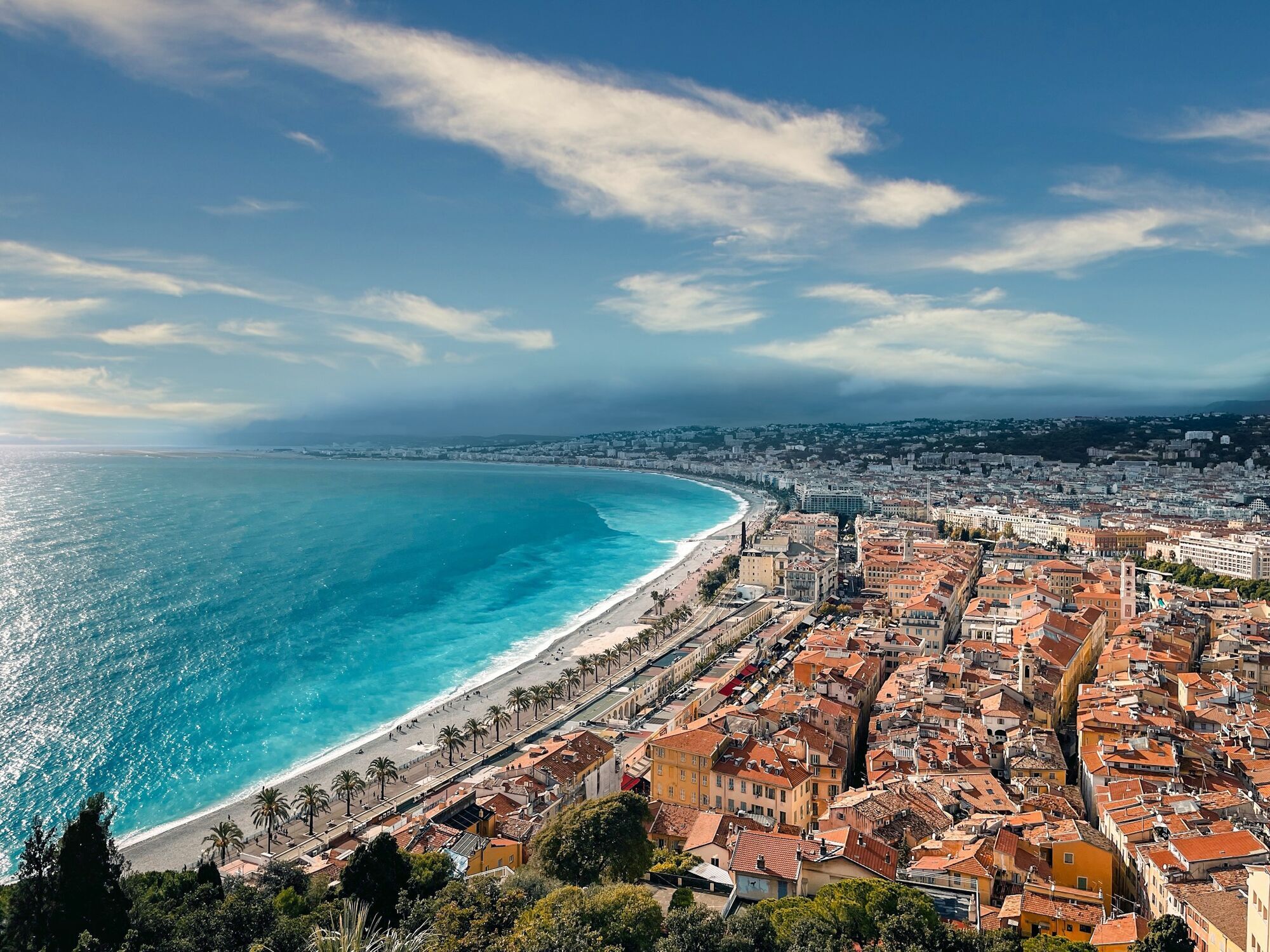Aerial view of Nice coastline with turquoise water and dense city buildings