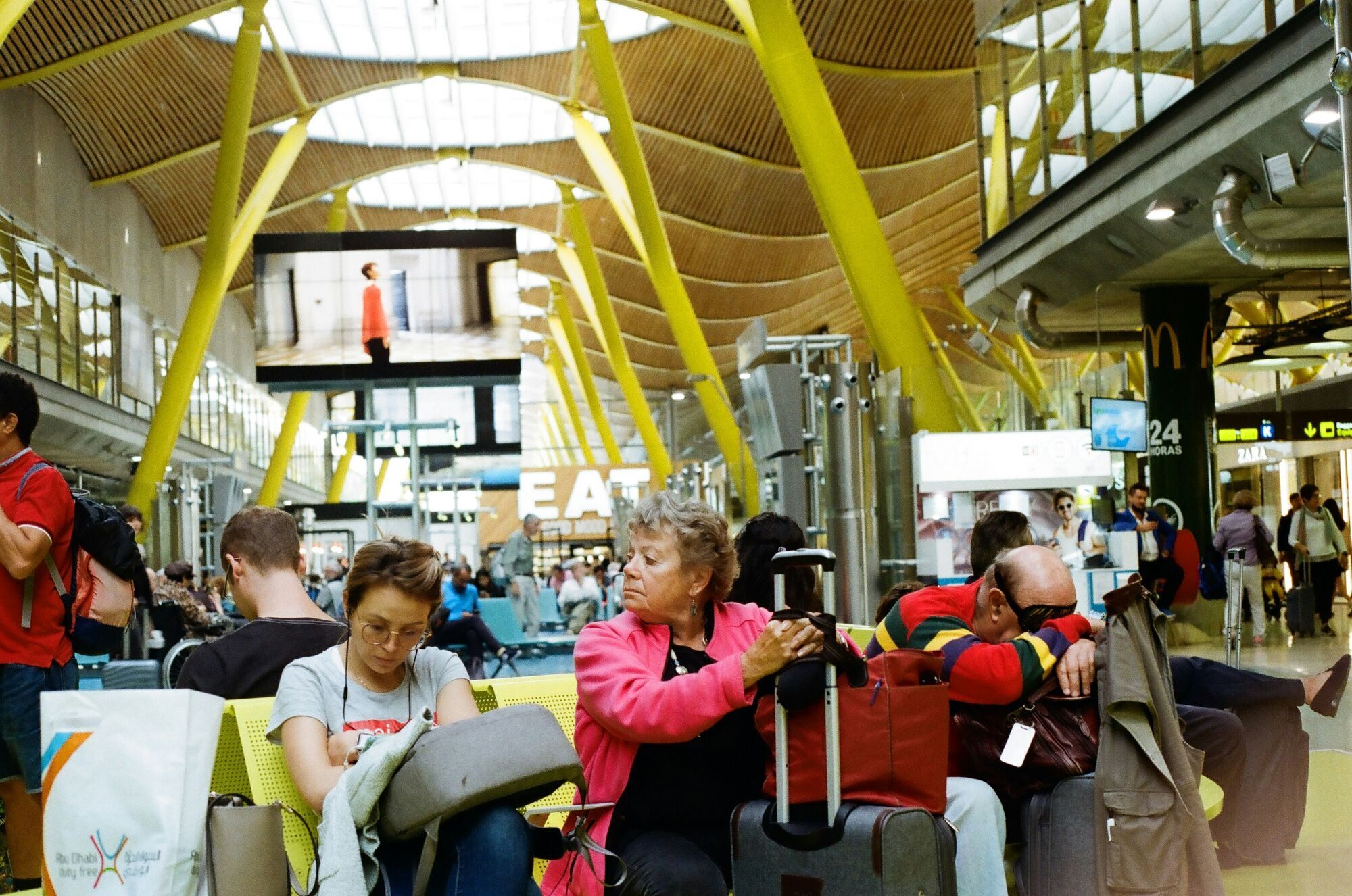 Passengers waiting in an airport terminal with luggage