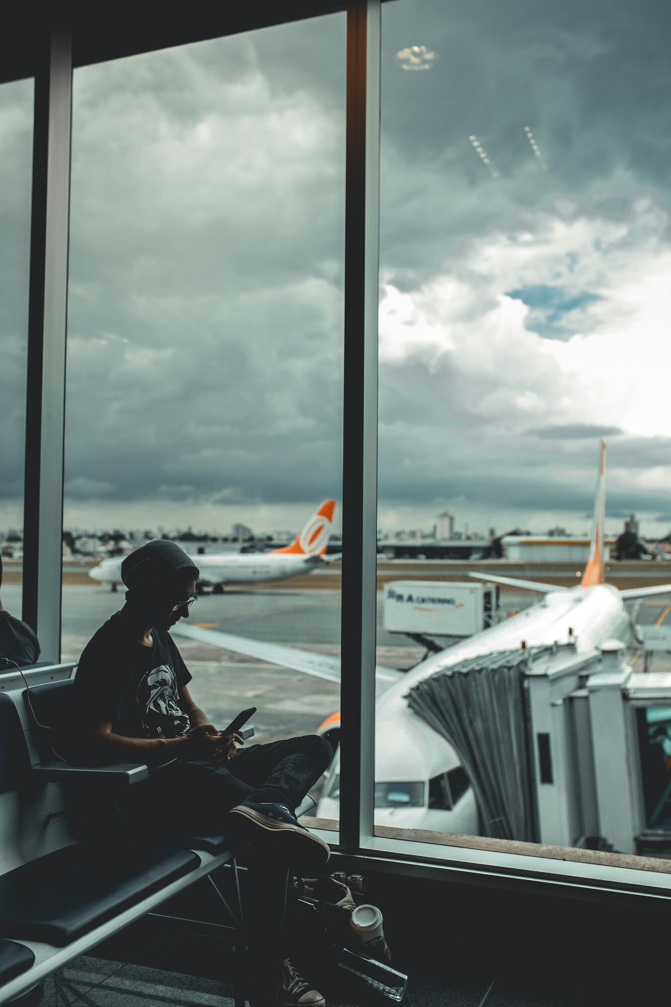 Passenger waiting beside an airport window