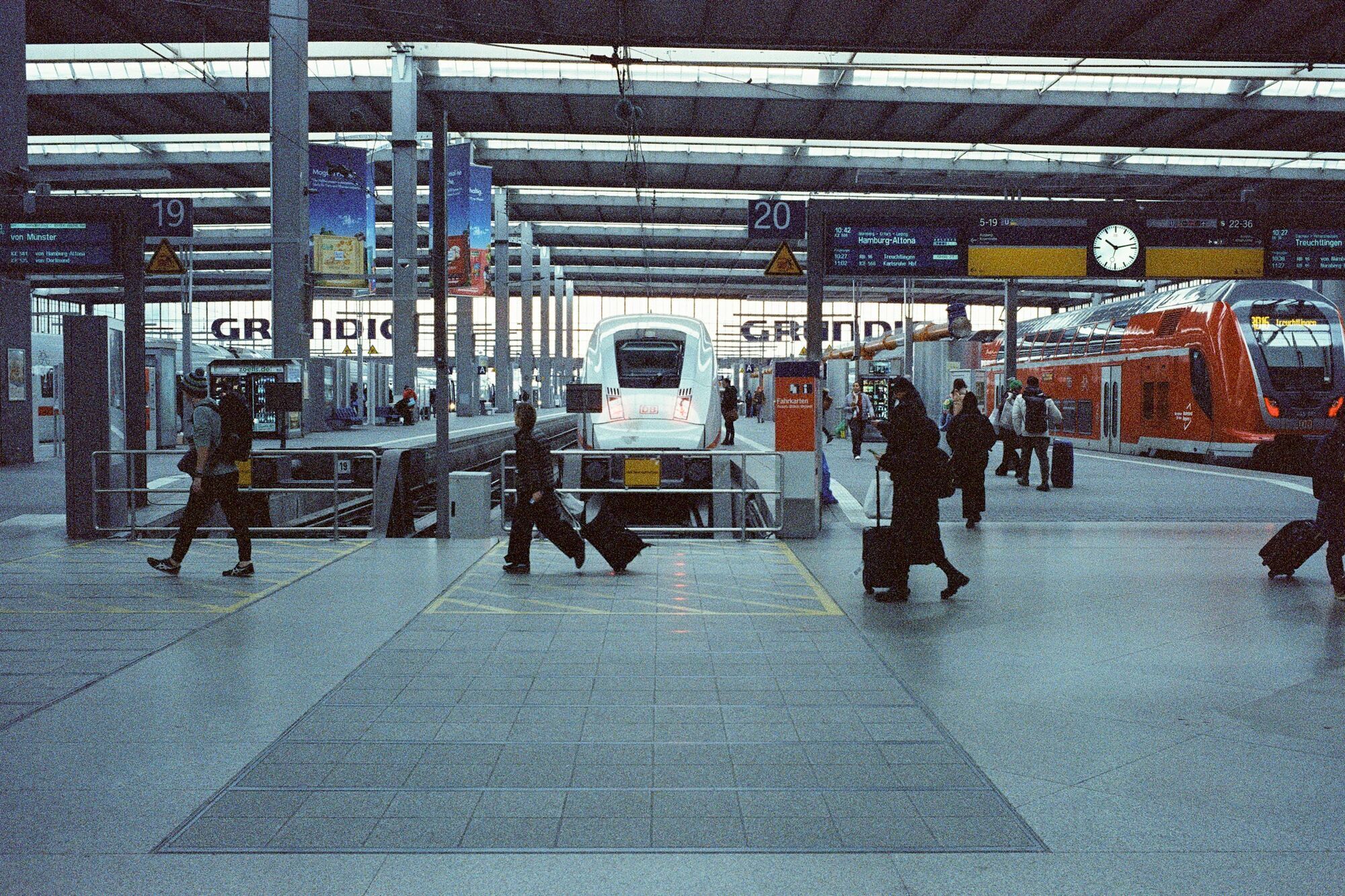 Passengers walking past trains at a German railway station