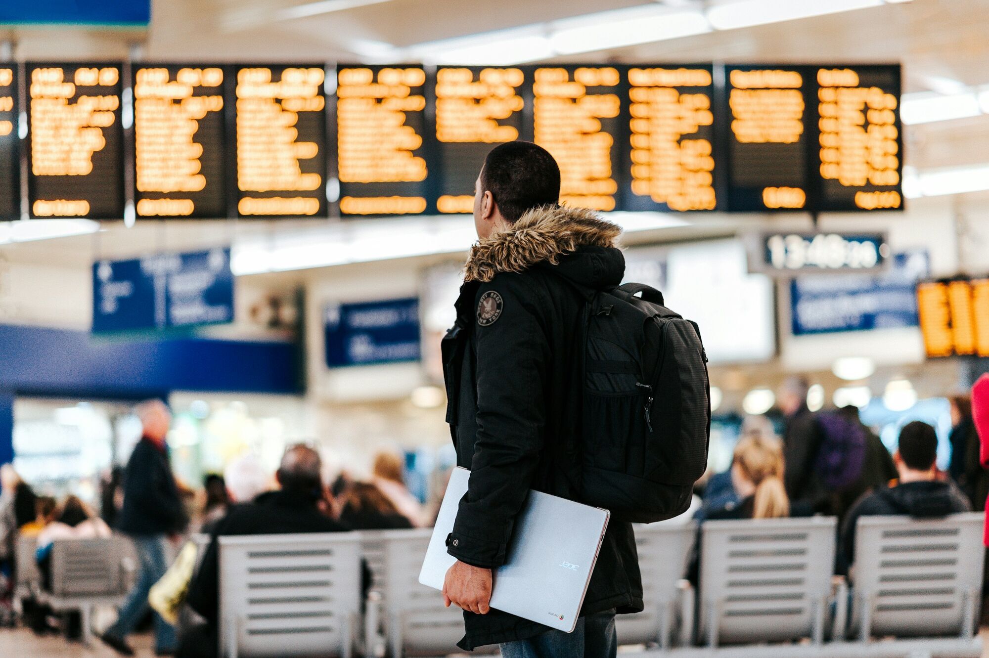 Passenger checking departure boards at airport terminal