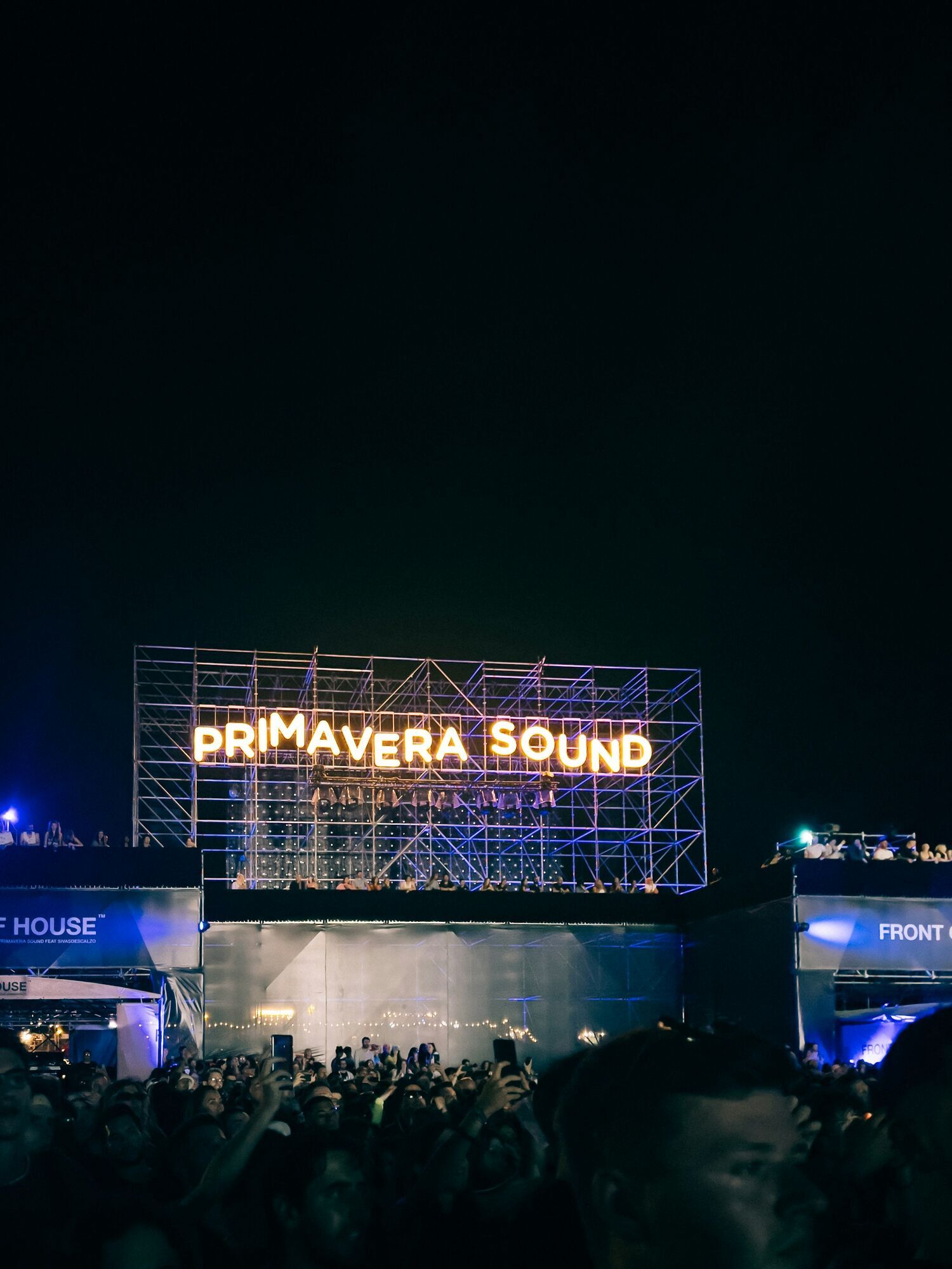 Illuminated Primavera Sound festival sign above a crowd at night