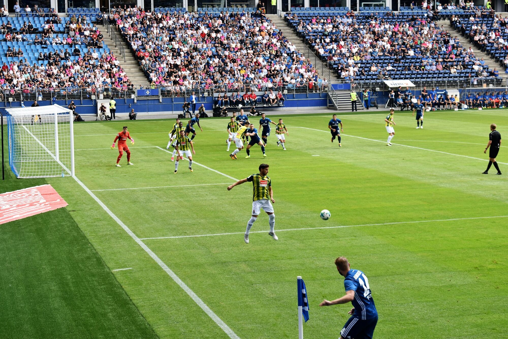 Football players competing during a match in front of crowded stands