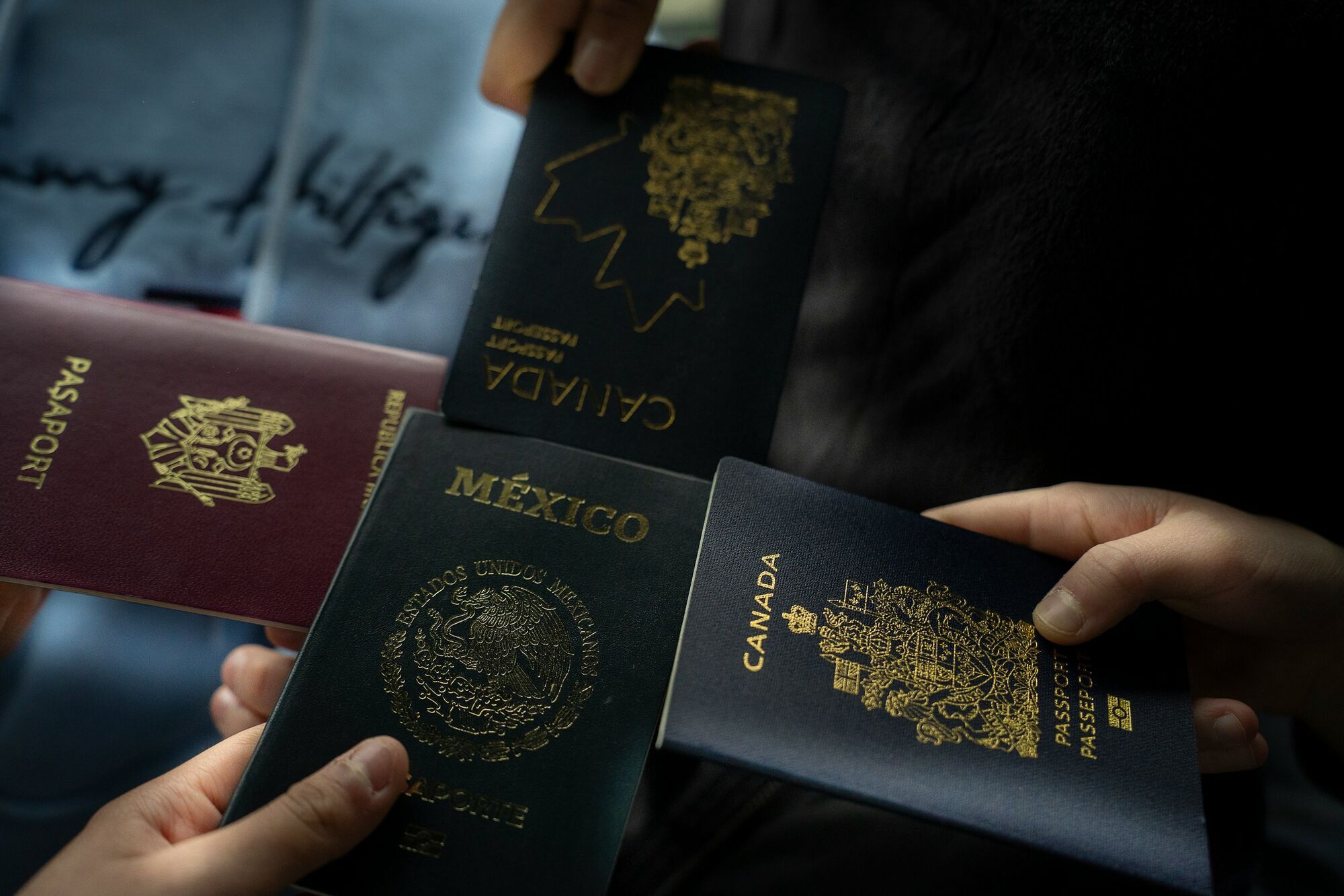 Hands holding Canadian, Mexican and Moldovan passports