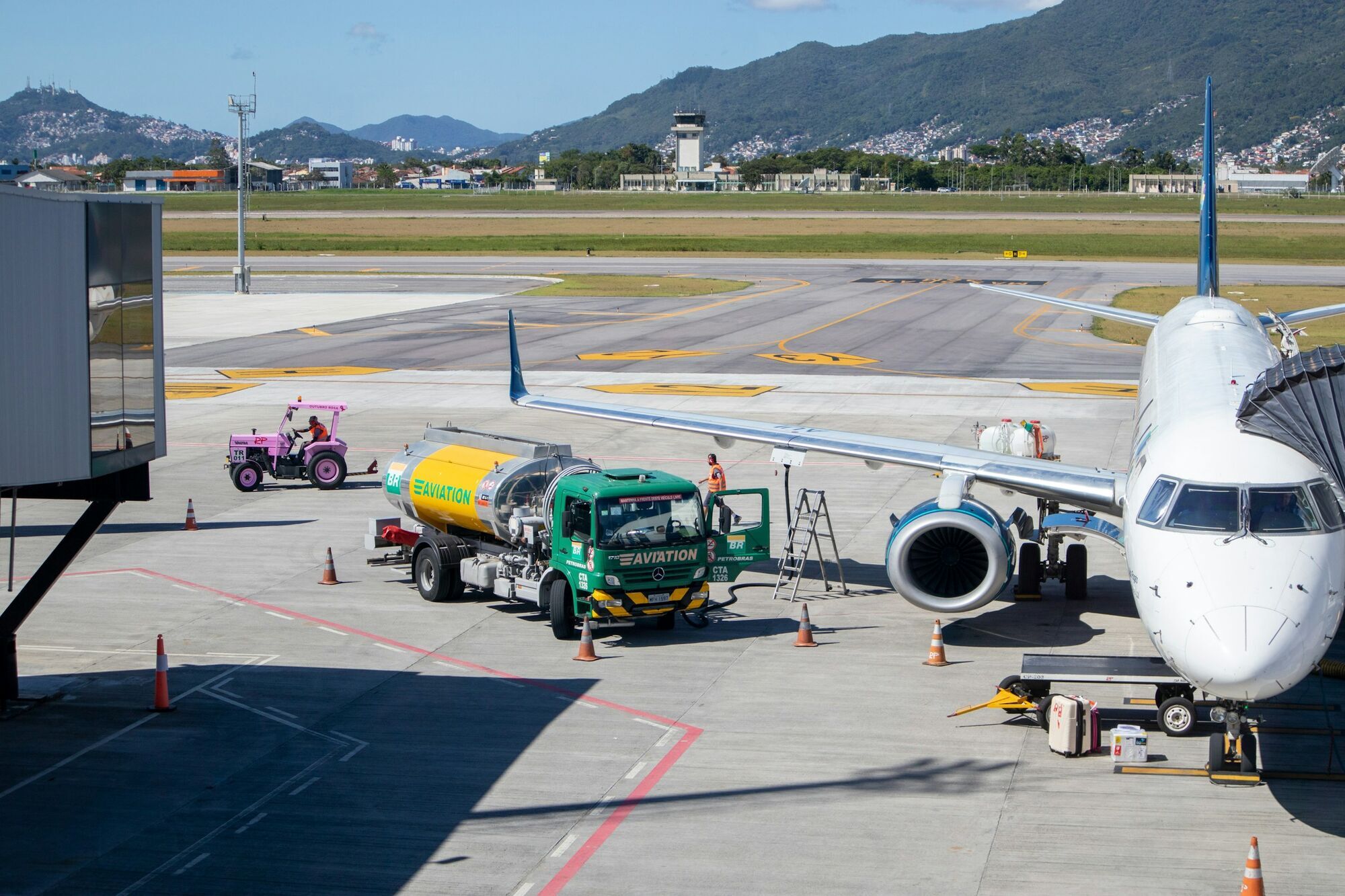 Aviation fuel tanker beside a passenger aircraft at an airport