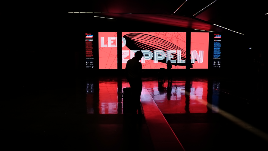 Visitors silhouetted against a red Led Zeppelin installation at the Rock Icons exhibition