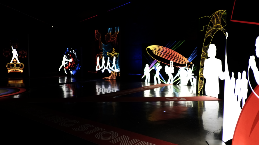 Colourful illuminated silhouettes and rock music artwork inside the Rock Icons exhibition