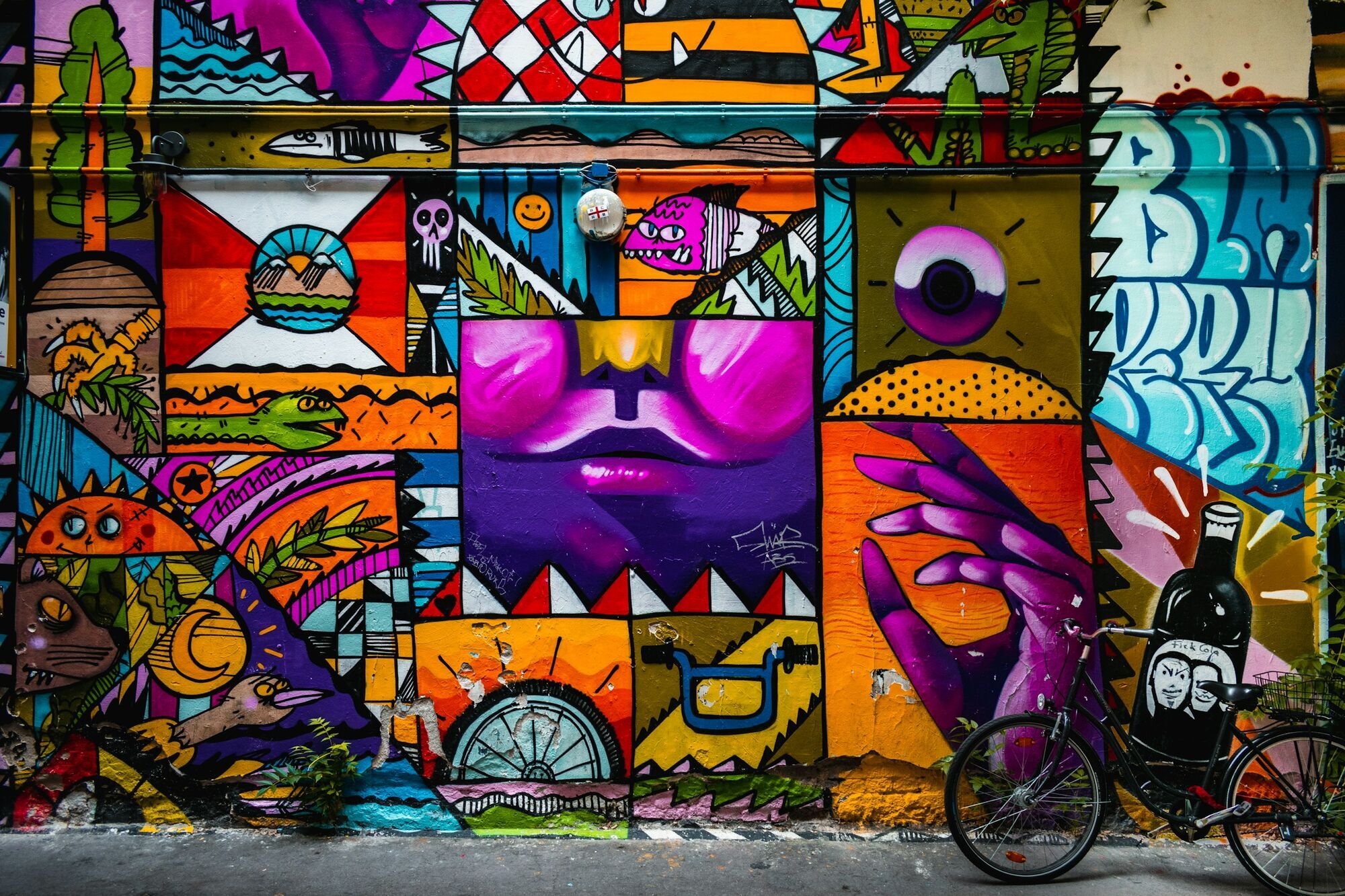 Colourful graffiti mural featuring abstract faces and figures on a Lisbon street