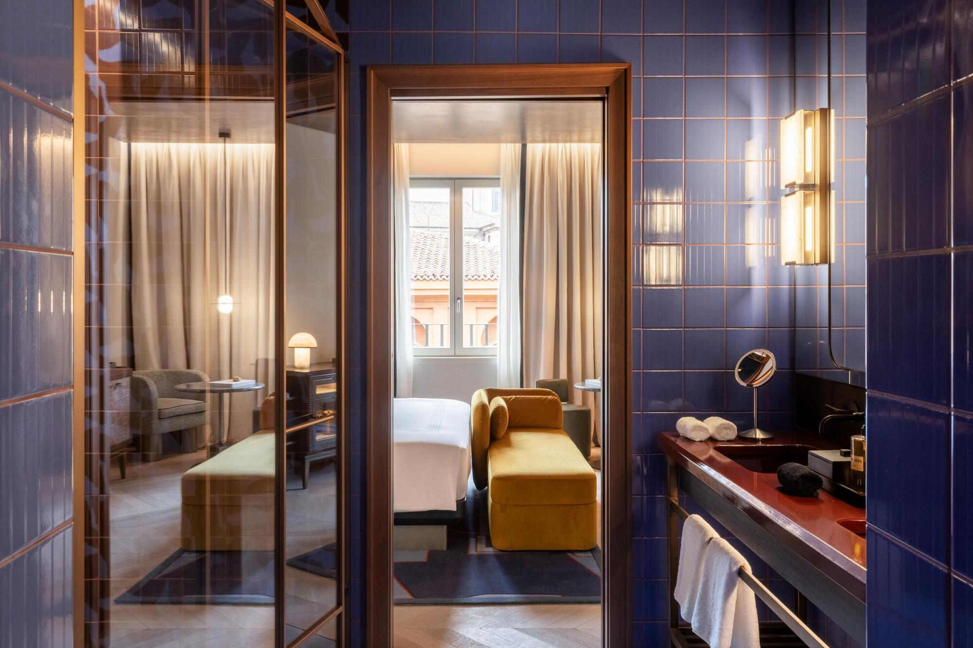 Blue-tiled bathroom opening onto a guestroom at Thompson Rome