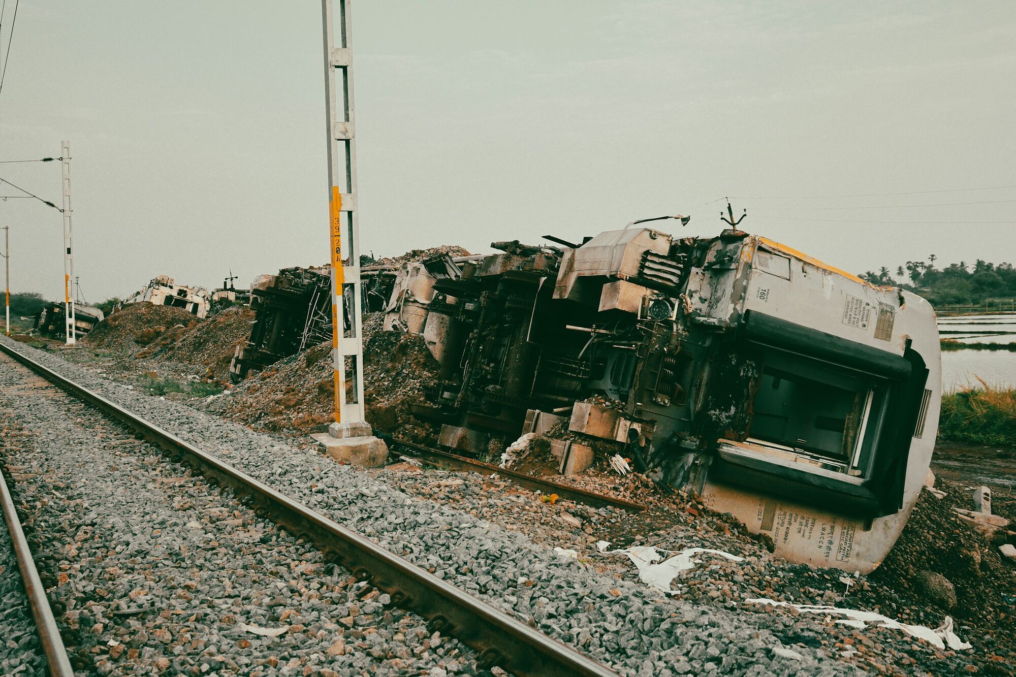 Derailed train carriages lying beside a railway track