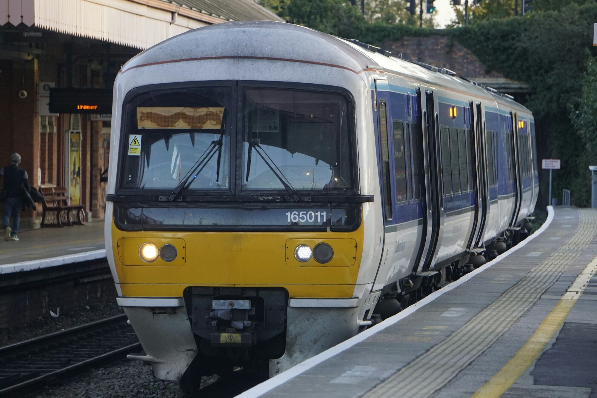 Blue and yellow passenger train standing at a railway platform