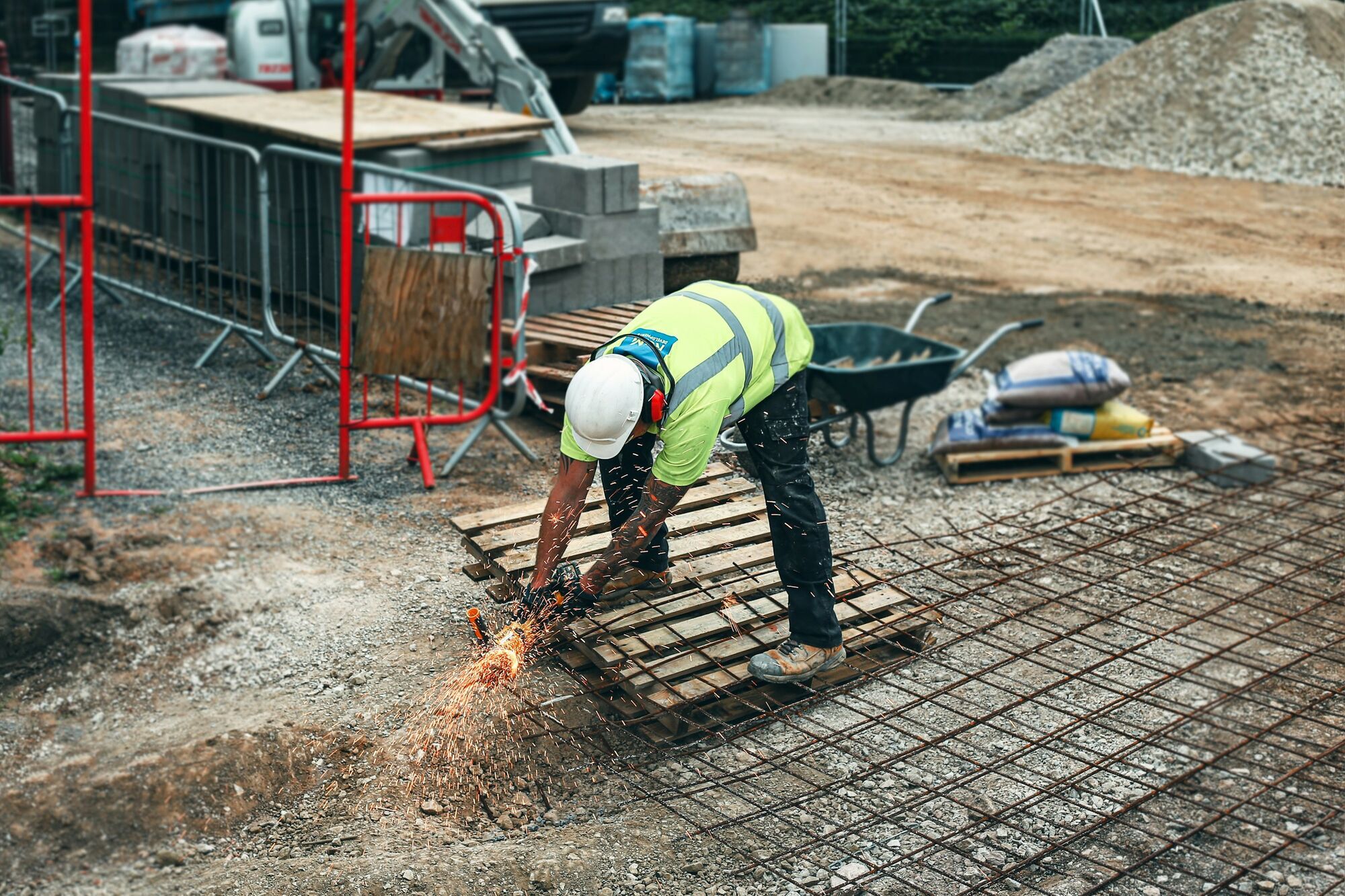 Construction worker cutting steel reinforcement with a power tool