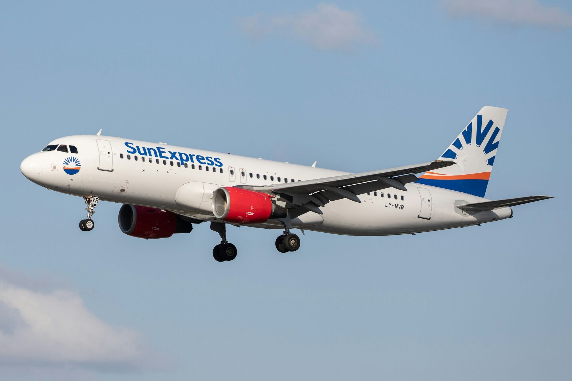 SunExpress aircraft flying against a blue sky
