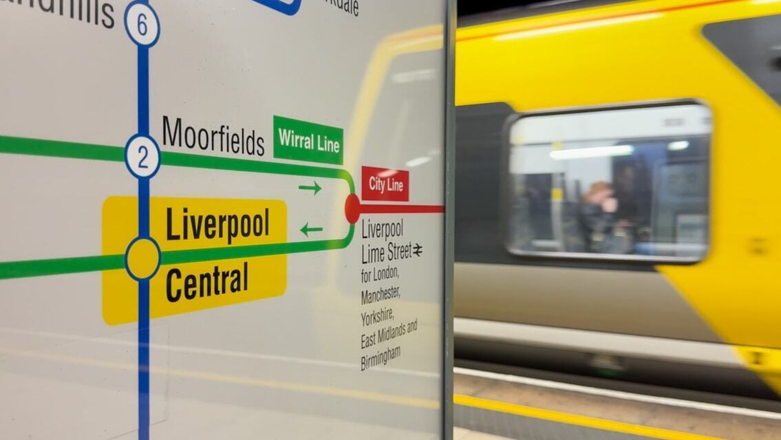 Merseyrail train beside Liverpool Central map