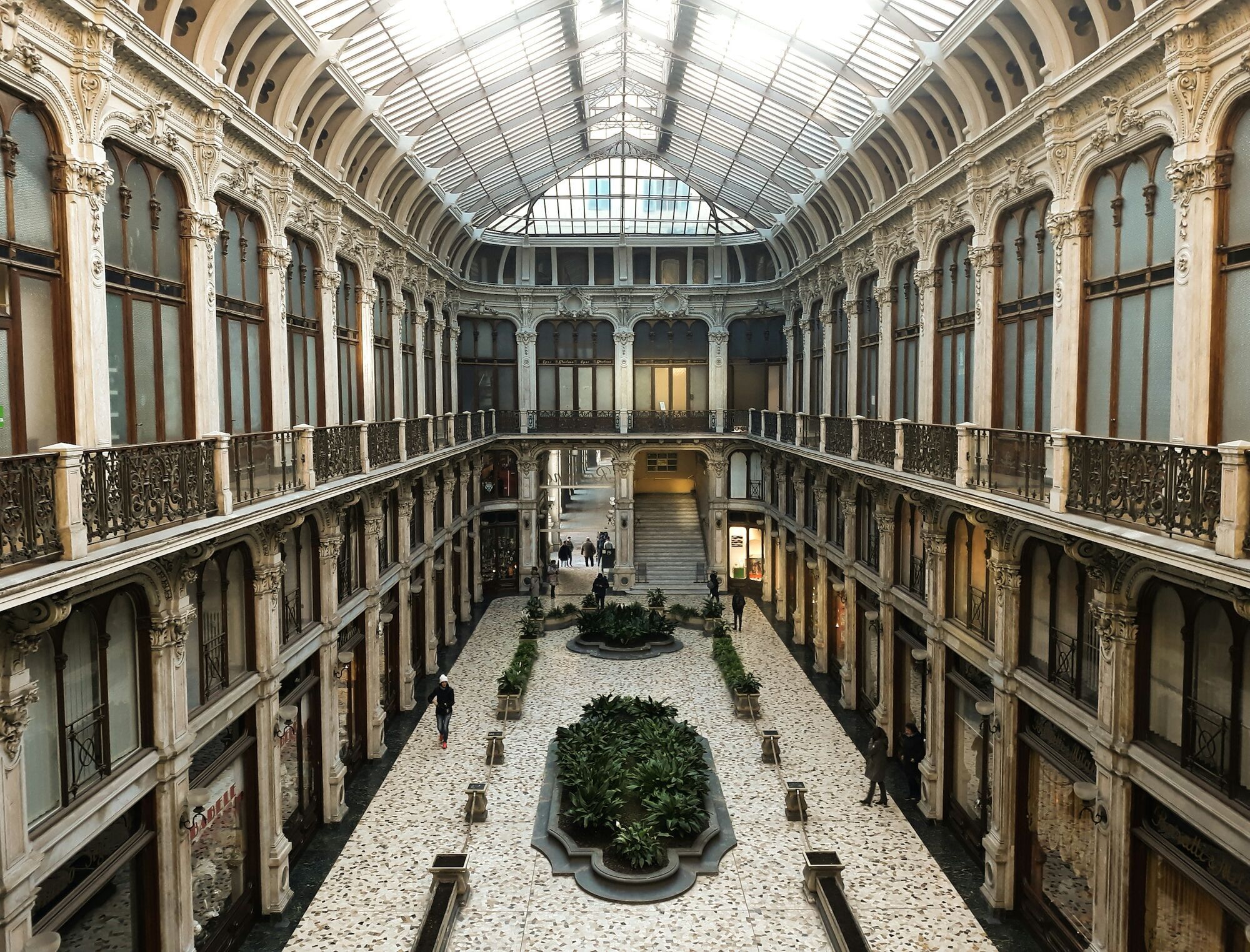 Historic covered arcade in central Turin with glass roof and ornate balconies