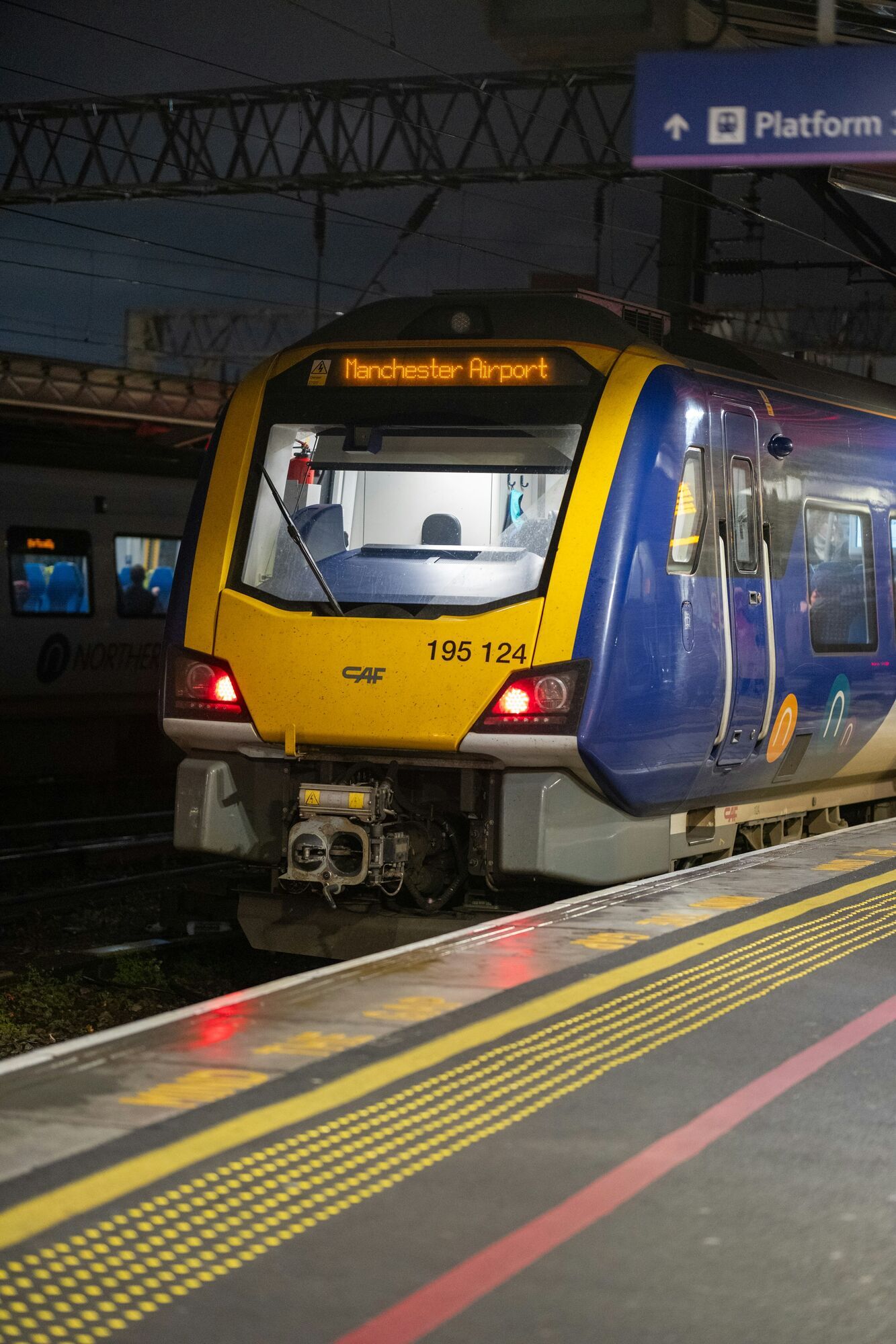Northern train at platform displaying Manchester Airport destination