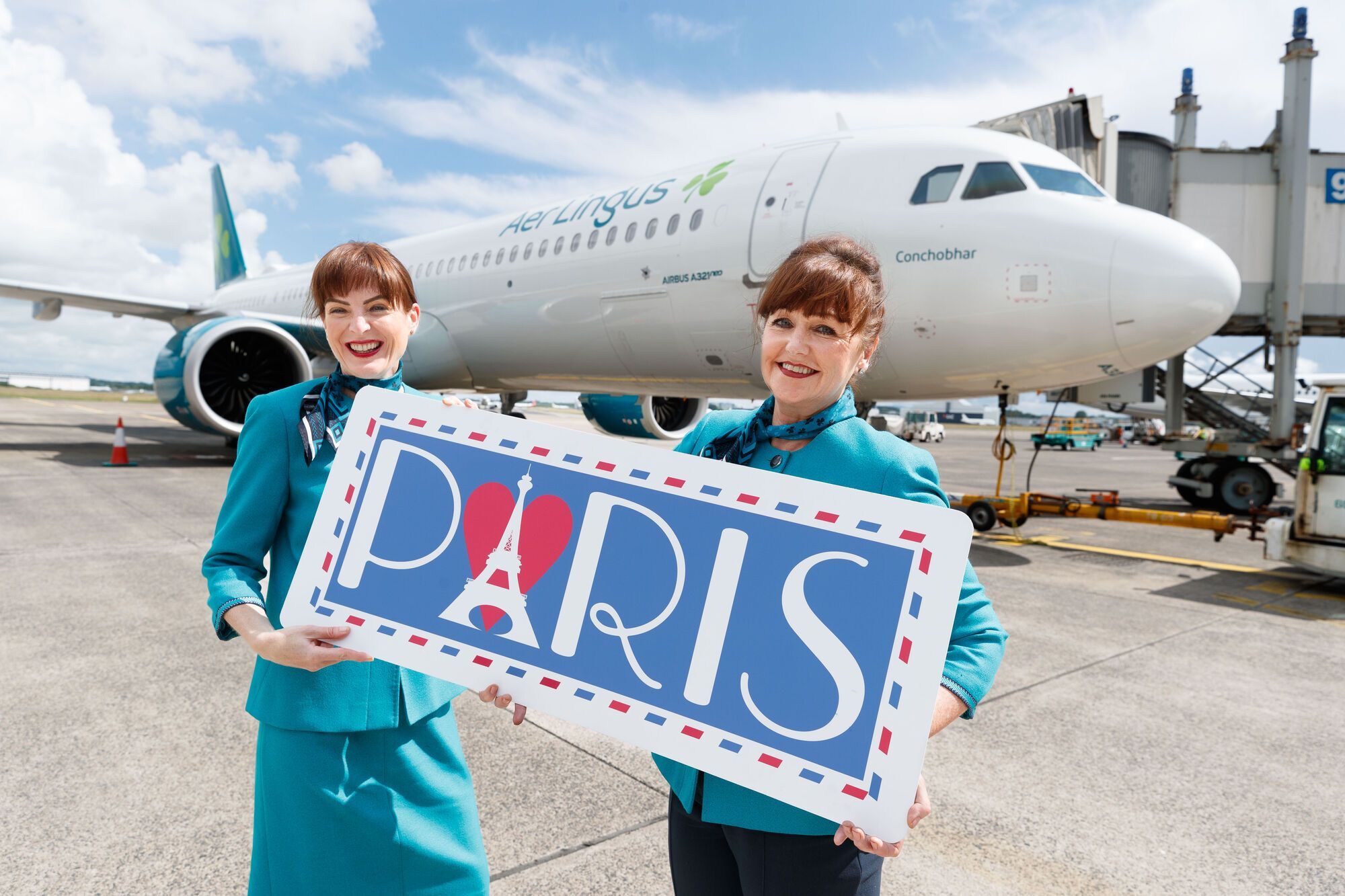 Aer Lingus crew at Shannon Airport holding Paris route sign in front of aircraft